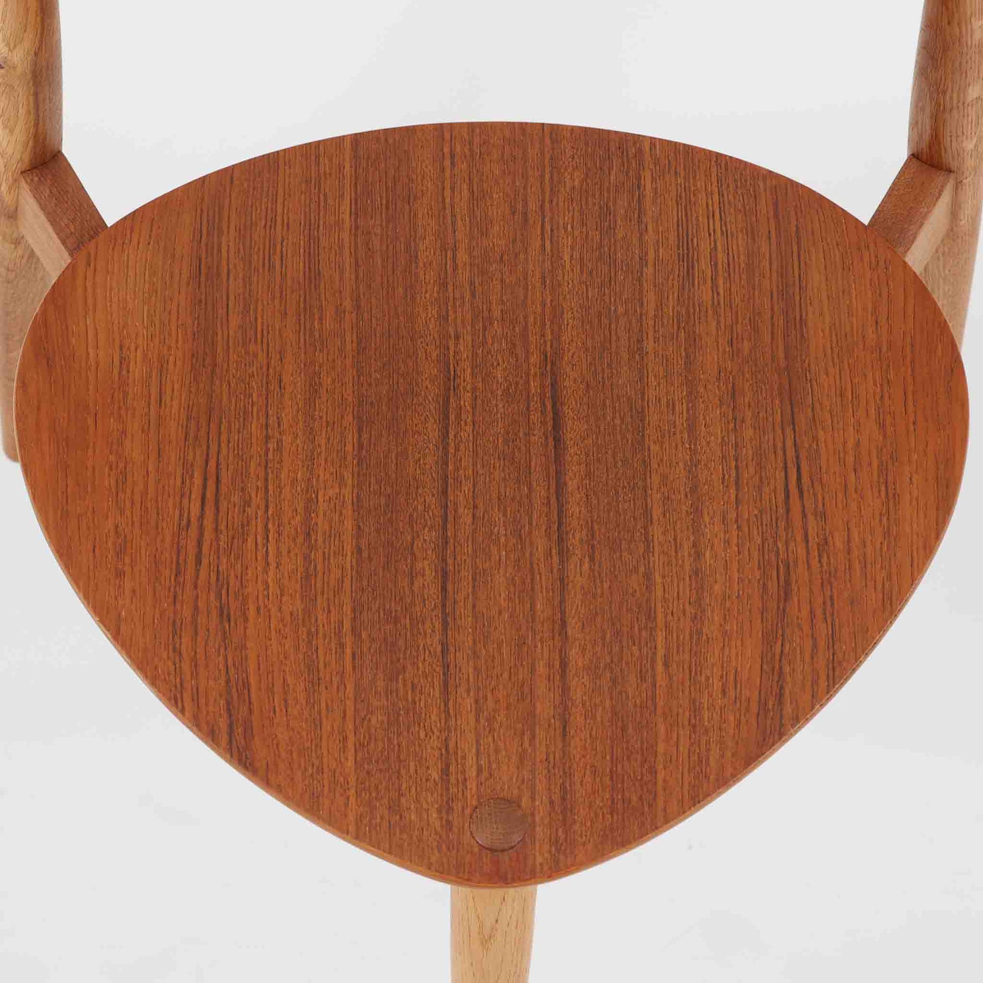 Hans J. Wegnerがデザインし、Fritz Hansen社より発表されたFH4103チェアは、三角形に近い座面と滑らかな曲線を描く笠木が特徴の北欧ビンテージ家具です。フレームには堅牢なオーク材、座面には温かみあるチーク材を組み合わせ、素材のコントラストが美しいバランスを生み出しています。彫刻的なフォルムながら軽やかで実用的な構造は、ダイニングチェアとしてはもちろん、空間のアクセントピースとしても存在感を放ちます。経年による木肌の深い風合いが、ビンテージならではの魅力を引き立てています。