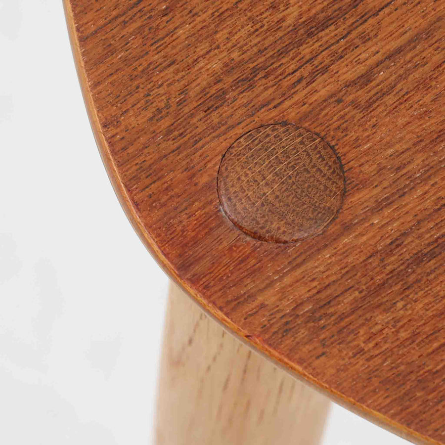 Hans J. Wegnerがデザインし、Fritz Hansen社より発表されたFH4103チェアは、三角形に近い座面と滑らかな曲線を描く笠木が特徴の北欧ビンテージ家具です。フレームには堅牢なオーク材、座面には温かみあるチーク材を組み合わせ、素材のコントラストが美しいバランスを生み出しています。彫刻的なフォルムながら軽やかで実用的な構造は、ダイニングチェアとしてはもちろん、空間のアクセントピースとしても存在感を放ちます。経年による木肌の深い風合いが、ビンテージならではの魅力を引き立てています。