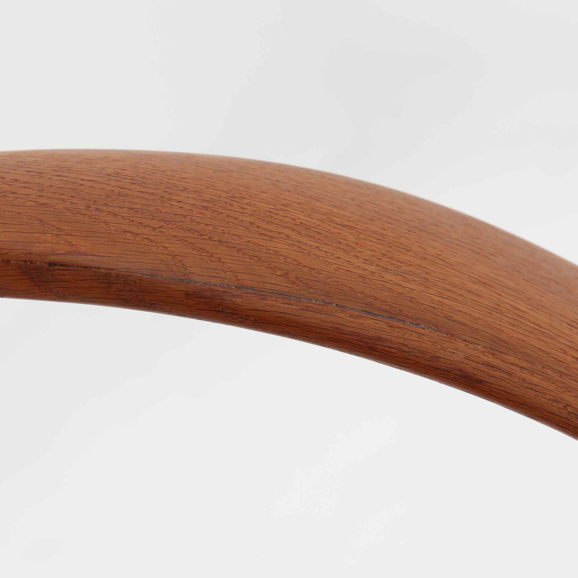 Hans J. Wegnerがデザインし、Fritz Hansen社より発表されたFH4103チェアは、三角形に近い座面と滑らかな曲線を描く笠木が特徴の北欧ビンテージ家具です。フレームには堅牢なオーク材、座面には温かみあるチーク材を組み合わせ、素材のコントラストが美しいバランスを生み出しています。彫刻的なフォルムながら軽やかで実用的な構造は、ダイニングチェアとしてはもちろん、空間のアクセントピースとしても存在感を放ちます。経年による木肌の深い風合いが、ビンテージならではの魅力を引き立てています。