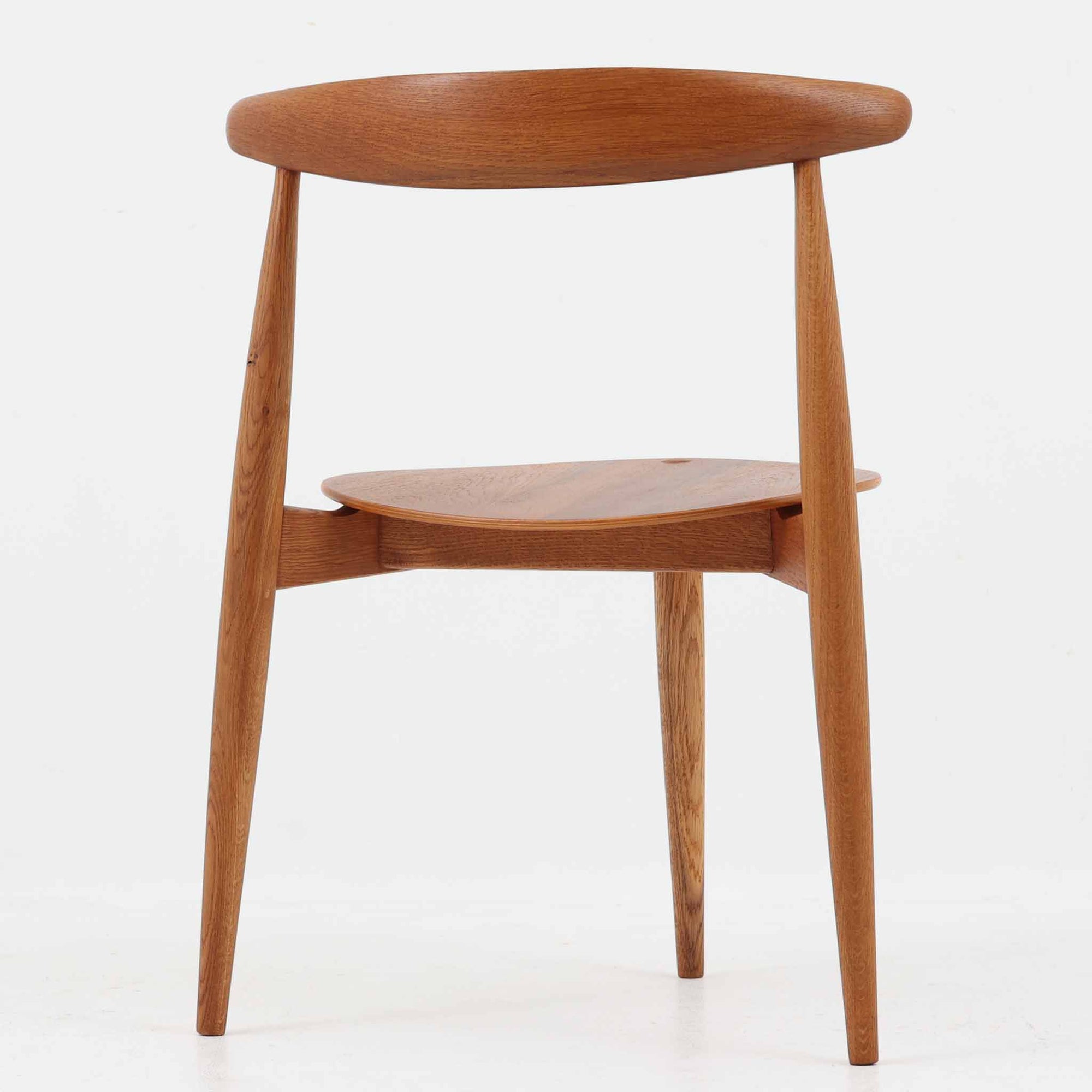 Hans J. Wegnerがデザインし、Fritz Hansen社より発表されたFH4103チェアは、三角形に近い座面と滑らかな曲線を描く笠木が特徴の北欧ビンテージ家具です。フレームには堅牢なオーク材、座面には温かみあるチーク材を組み合わせ、素材のコントラストが美しいバランスを生み出しています。彫刻的なフォルムながら軽やかで実用的な構造は、ダイニングチェアとしてはもちろん、空間のアクセントピースとしても存在感を放ちます。経年による木肌の深い風合いが、ビンテージならではの魅力を引き立てています。