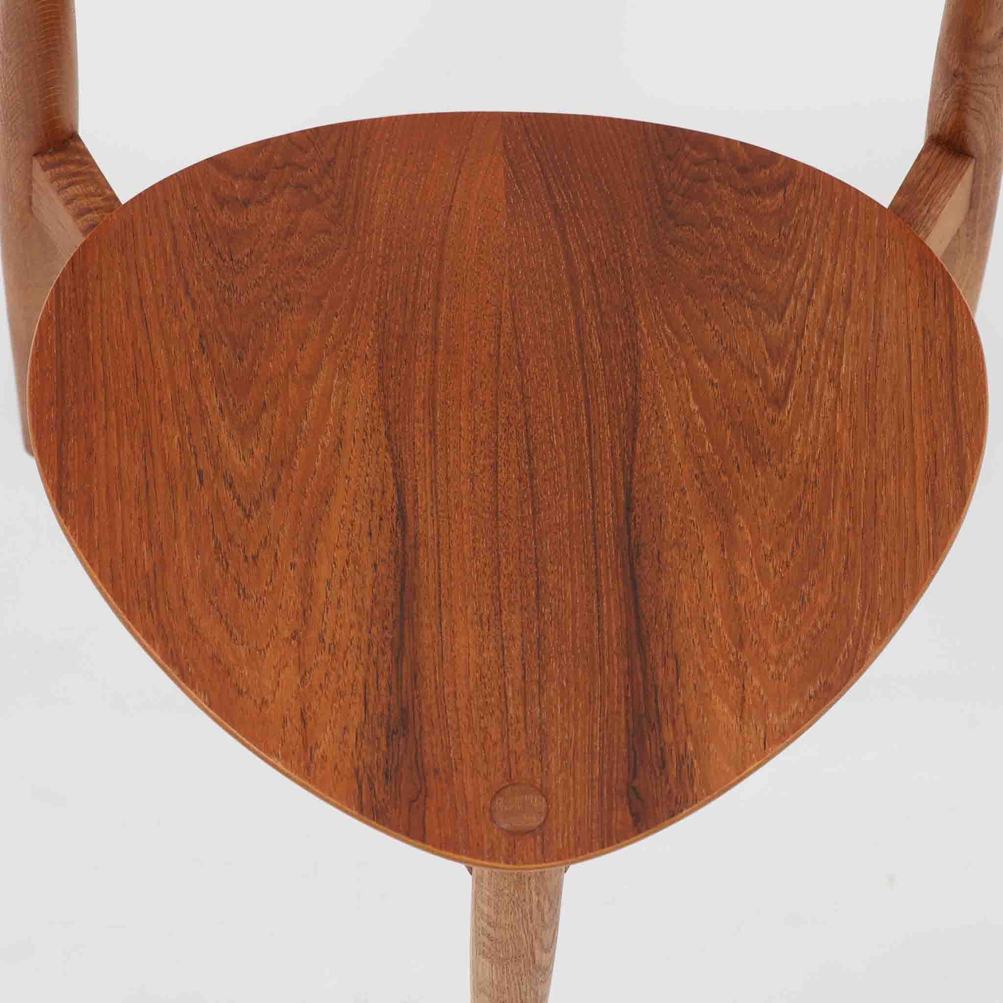 Hans J. Wegnerがデザインし、Fritz Hansen社より発表されたFH4103チェアは、三角形に近い座面と滑らかな曲線を描く笠木が特徴の北欧ビンテージ家具です。フレームには堅牢なオーク材、座面には温かみあるチーク材を組み合わせ、素材のコントラストが美しいバランスを生み出しています。彫刻的なフォルムながら軽やかで実用的な構造は、ダイニングチェアとしてはもちろん、空間のアクセントピースとしても存在感を放ちます。経年による木肌の深い風合いが、ビンテージならではの魅力を引き立てています。