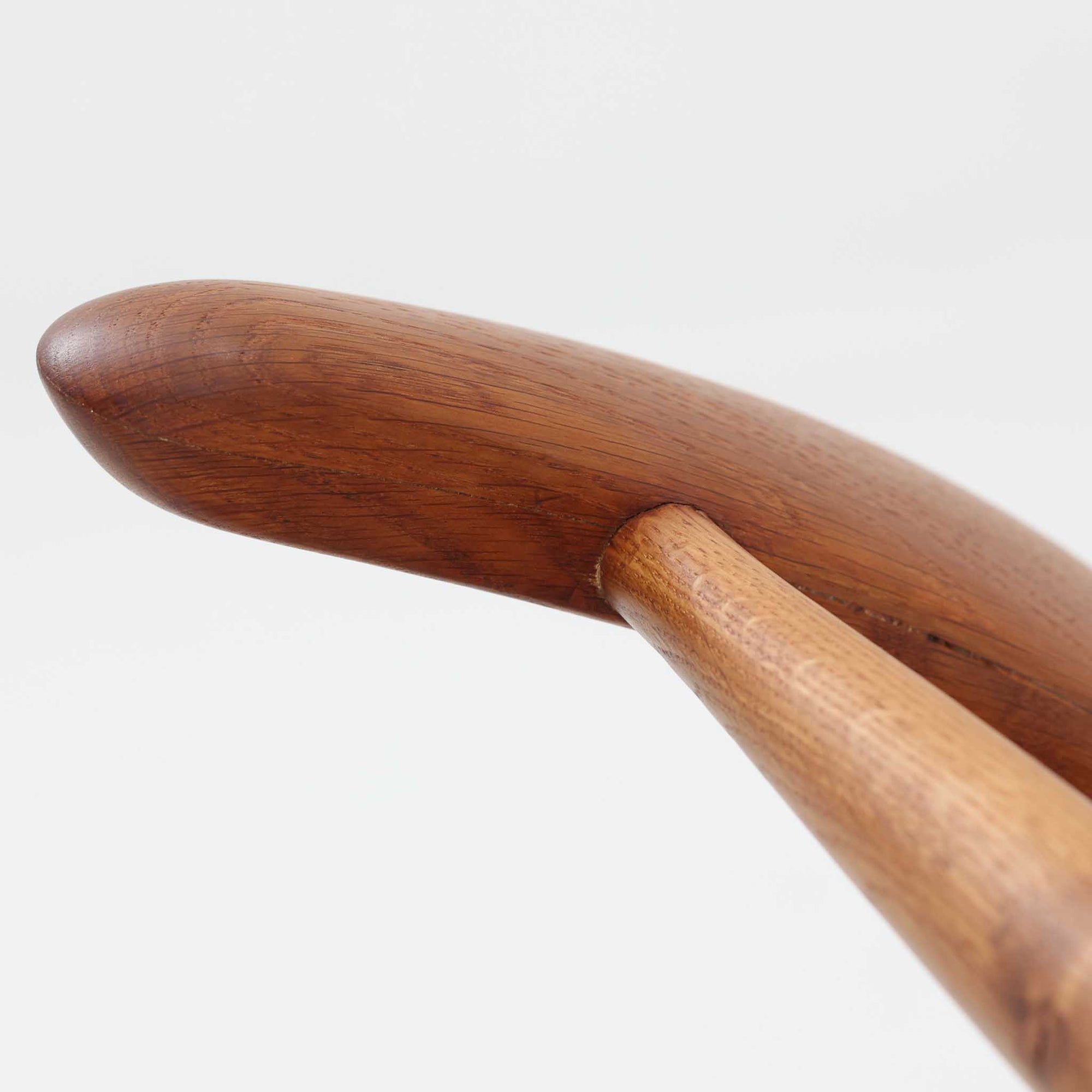 Hans J. Wegnerがデザインし、Fritz Hansen社より発表されたFH4103チェアは、三角形に近い座面と滑らかな曲線を描く笠木が特徴の北欧ビンテージ家具です。フレームには堅牢なオーク材、座面には温かみあるチーク材を組み合わせ、素材のコントラストが美しいバランスを生み出しています。彫刻的なフォルムながら軽やかで実用的な構造は、ダイニングチェアとしてはもちろん、空間のアクセントピースとしても存在感を放ちます。経年による木肌の深い風合いが、ビンテージならではの魅力を引き立てています。