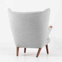 Hans J. Wegnerによってデザインされ、AP Stolen社より製造された名作AP-19、通称「ベアチェア」は、その名の通り熊が抱きかかえるような形状のアームが特徴のシングルソファです。張りぐるみのシートを支えるチーク材の脚部は、繊細さと力強さを兼ね備えた見事な造形で、ウェグナーらしい有機的なフォルムと高い快適性が融合した一台です。張地にはグレー系のファブリックを使用し、空間に馴染みやすい落ち着いた印象に仕上げられています。名作ゆえに現存数も限られ、ビンテージ市場でも高い評価を受ける希少な逸品です。