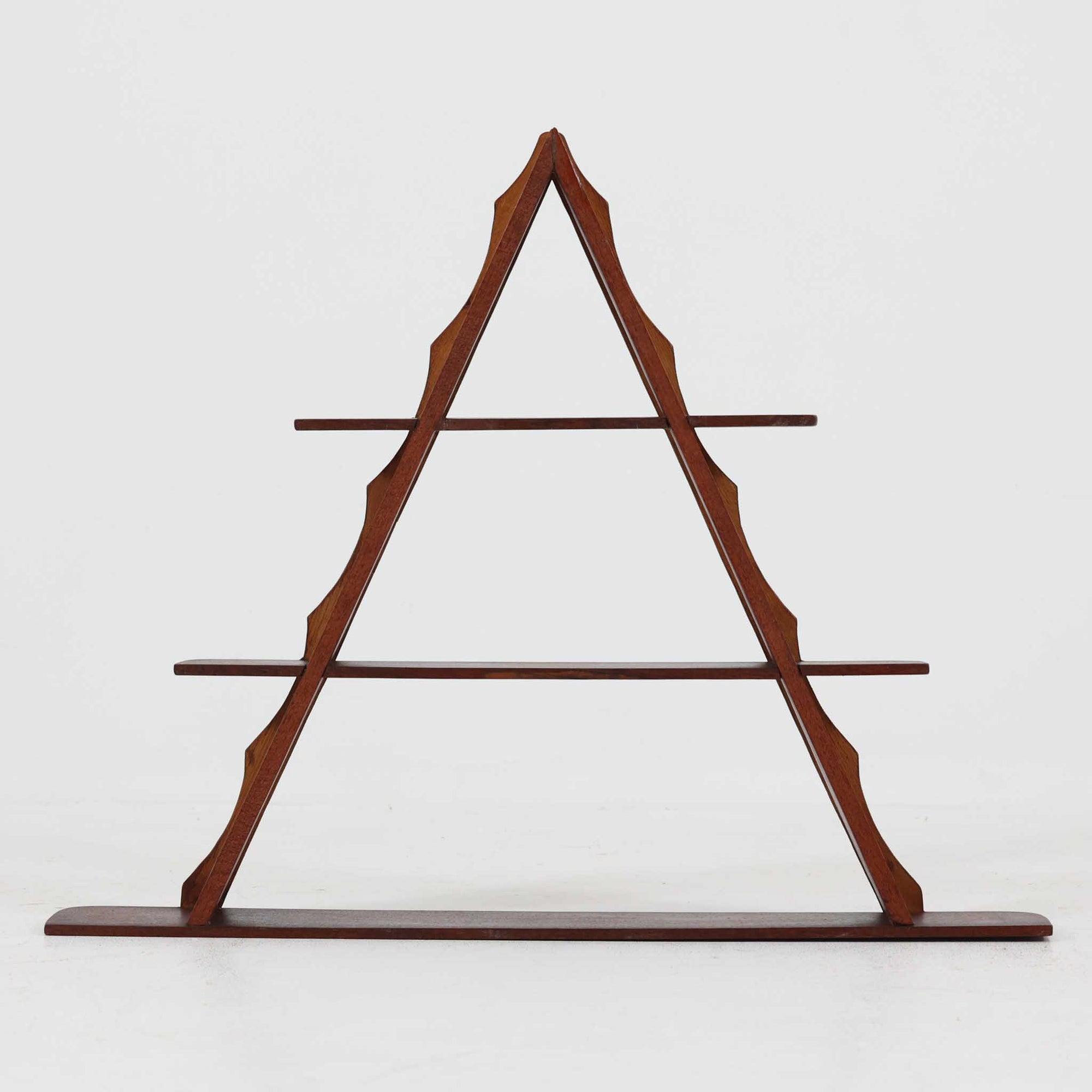 ユニークな三角形のフレームが印象的なこちらのウォールシェルフは、チーク材の温もりと美しい木目が魅力の北欧ビンテージ品です。棚板は3段構成で、小さなオブジェやカップ、植物などをディスプレイするのに最適なサイズ感。壁掛けとしても自立型としても使えるため、用途に合わせて自由なレイアウトが可能です。空間に個性を添えるアートピースのような存在で、経年変化による風合いもお楽しみいただけます。