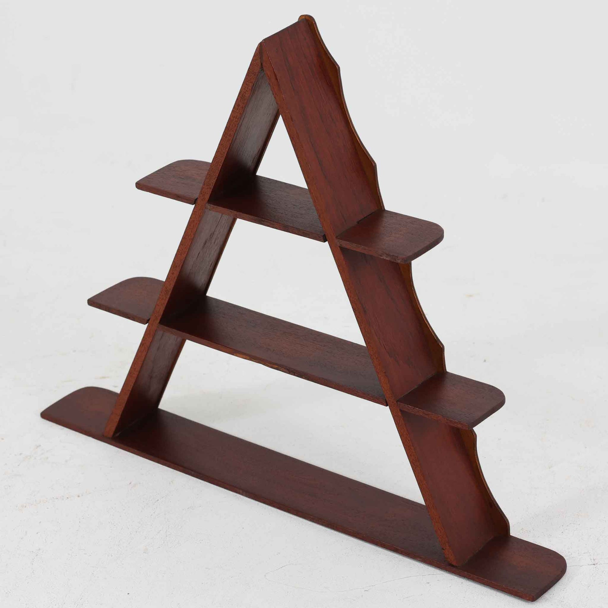 ユニークな三角形のフレームが印象的なこちらのウォールシェルフは、チーク材の温もりと美しい木目が魅力の北欧ビンテージ品です。棚板は3段構成で、小さなオブジェやカップ、植物などをディスプレイするのに最適なサイズ感。壁掛けとしても自立型としても使えるため、用途に合わせて自由なレイアウトが可能です。空間に個性を添えるアートピースのような存在で、経年変化による風合いもお楽しみいただけます。