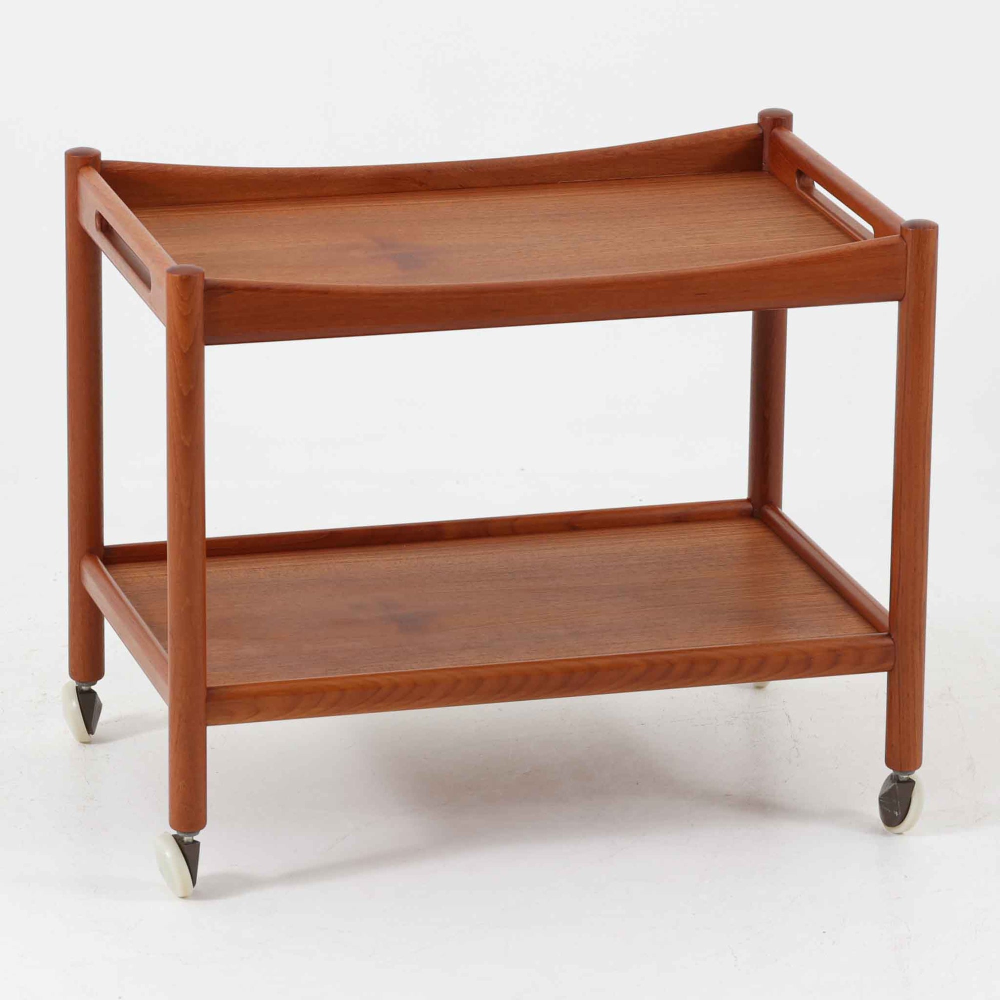 Hans J. Wegnerがデザインし、Andreas Tuck社より製造されたキャスターワゴン「AT45」は、チーク材の豊かな表情と機能美が融合した北欧ビンテージの逸品です。両サイドには持ち運びに便利な取っ手が付き、脚先にはスムーズに動くキャスターを備えているため、サービングや配膳台として活躍します。緩やかな曲線を描くフレームと丁寧な仕上げに、ウェグナーらしい美意識が宿る一台です。