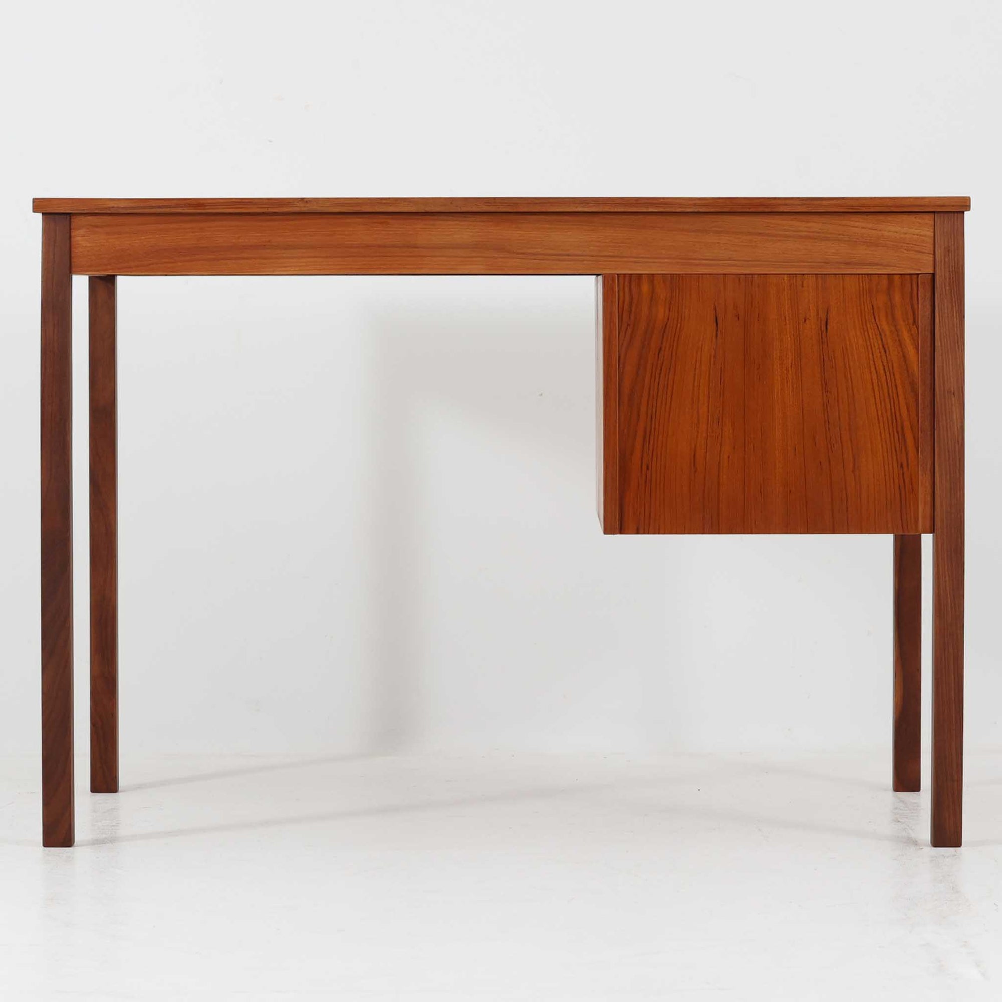 デンマーク製の片袖デスクは、北欧ビンテージ家具らしい端正な佇まいが魅力です。チーク材を用いた温かみのある色合いと、美しい木目が空間に上質な雰囲気を添えます。幅104cmとコンパクトなサイズ感でありながら、左側に3杯の引き出しを備え、上段は鍵付きで大切な書類や小物を安心して収納可能。シンプルながら堅牢な造りと細部まで行き届いた職人技が感じられ、長年の使用にも耐えうる実用性を兼ね備えています。ワークデスクや書斎机としてはもちろん、リビングや寝室に置いても自然に馴染み、北欧家具ならではの温もりと機能美を楽しめる一台です。
