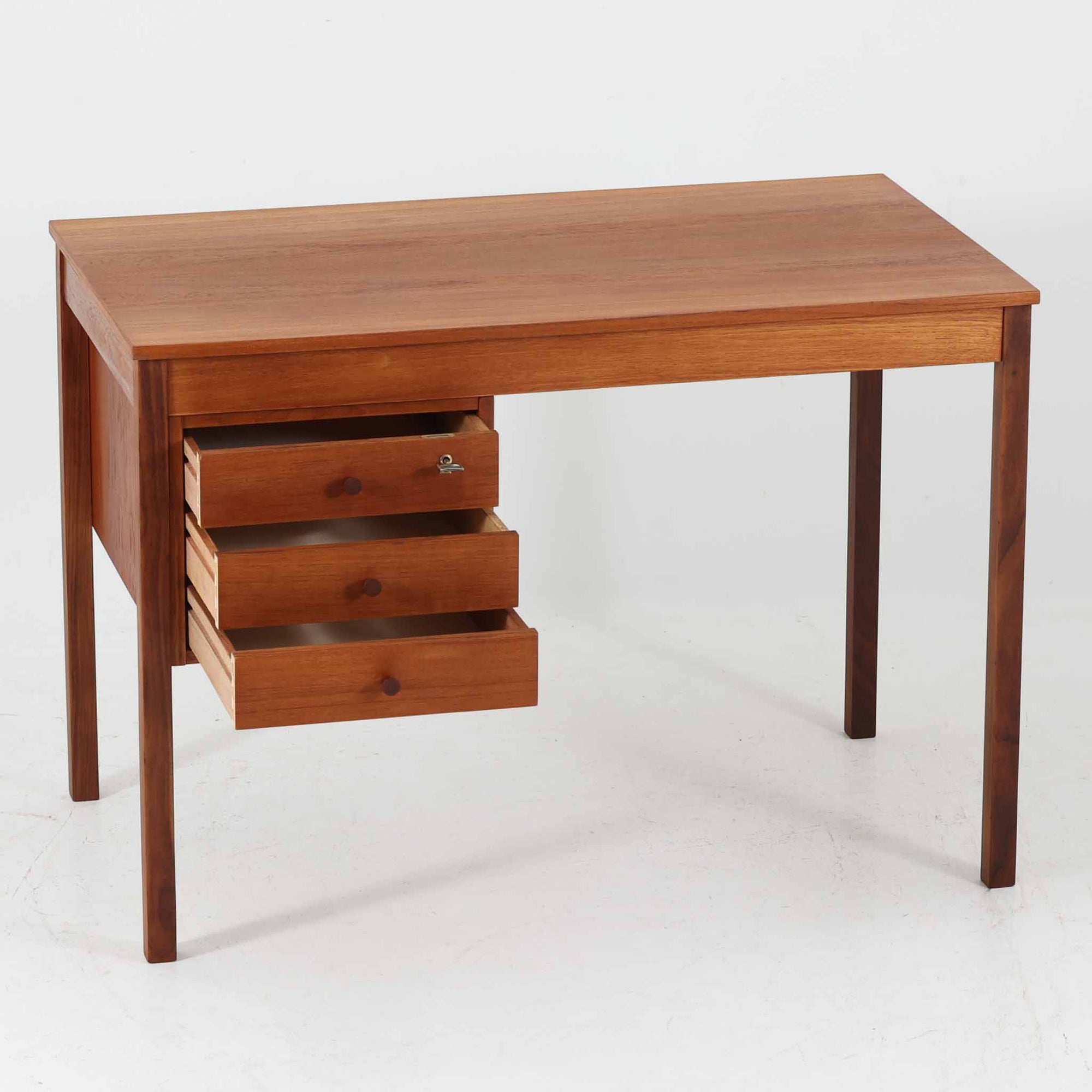 デンマーク製の片袖デスクは、北欧ビンテージ家具らしい端正な佇まいが魅力です。チーク材を用いた温かみのある色合いと、美しい木目が空間に上質な雰囲気を添えます。幅104cmとコンパクトなサイズ感でありながら、左側に3杯の引き出しを備え、上段は鍵付きで大切な書類や小物を安心して収納可能。シンプルながら堅牢な造りと細部まで行き届いた職人技が感じられ、長年の使用にも耐えうる実用性を兼ね備えています。ワークデスクや書斎机としてはもちろん、リビングや寝室に置いても自然に馴染み、北欧家具ならではの温もりと機能美を楽しめる一台です。