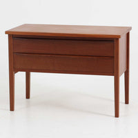 デンマーク製2段チェストです。無駄のないシンプルなフォルムとチーク材特有の深みのある色合いが美しく、北欧らしい上品な佇まいを感じさせます。引き出しの前板にはデンマーク家具らしい取手が施され、素材の質感を引き立てるデザインです。上段には仕切りが設けられており、小物の整理にも便利です。コンパクトなサイズながら収納力があり、リビングやベッドサイドなど幅広いシーンで活躍します。経年により艶を増した木肌が空間に温もりを添える一品です。