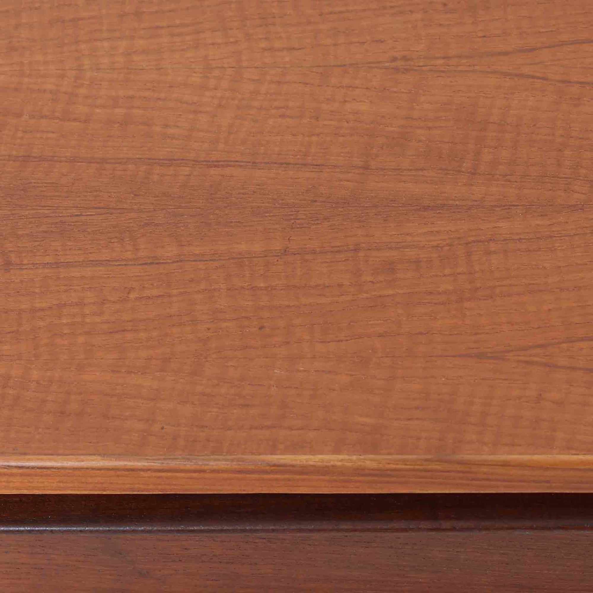 デンマーク製2段チェストです。無駄のないシンプルなフォルムとチーク材特有の深みのある色合いが美しく、北欧らしい上品な佇まいを感じさせます。引き出しの前板にはデンマーク家具らしい取手が施され、素材の質感を引き立てるデザインです。上段には仕切りが設けられており、小物の整理にも便利です。コンパクトなサイズながら収納力があり、リビングやベッドサイドなど幅広いシーンで活躍します。経年により艶を増した木肌が空間に温もりを添える一品です。