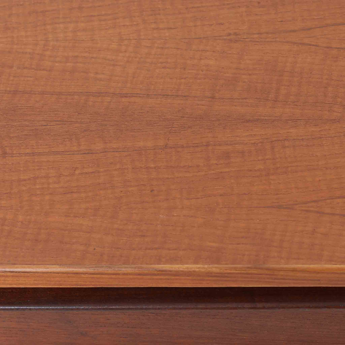 デンマーク製2段チェストです。無駄のないシンプルなフォルムとチーク材特有の深みのある色合いが美しく、北欧らしい上品な佇まいを感じさせます。引き出しの前板にはデンマーク家具らしい取手が施され、素材の質感を引き立てるデザインです。上段には仕切りが設けられており、小物の整理にも便利です。コンパクトなサイズながら収納力があり、リビングやベッドサイドなど幅広いシーンで活躍します。経年により艶を増した木肌が空間に温もりを添える一品です。