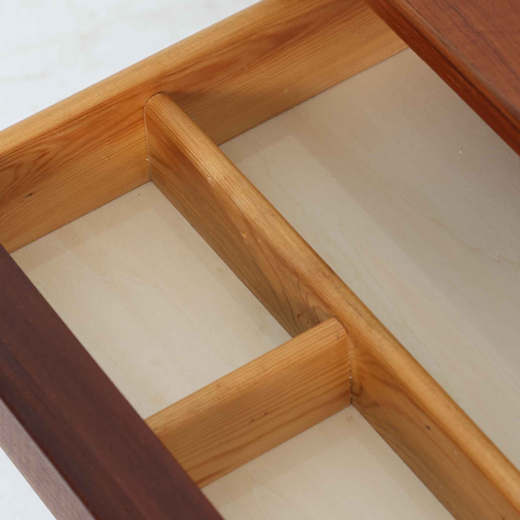 デンマーク製2段チェストです。無駄のないシンプルなフォルムとチーク材特有の深みのある色合いが美しく、北欧らしい上品な佇まいを感じさせます。引き出しの前板にはデンマーク家具らしい取手が施され、素材の質感を引き立てるデザインです。上段には仕切りが設けられており、小物の整理にも便利です。コンパクトなサイズながら収納力があり、リビングやベッドサイドなど幅広いシーンで活躍します。経年により艶を増した木肌が空間に温もりを添える一品です。