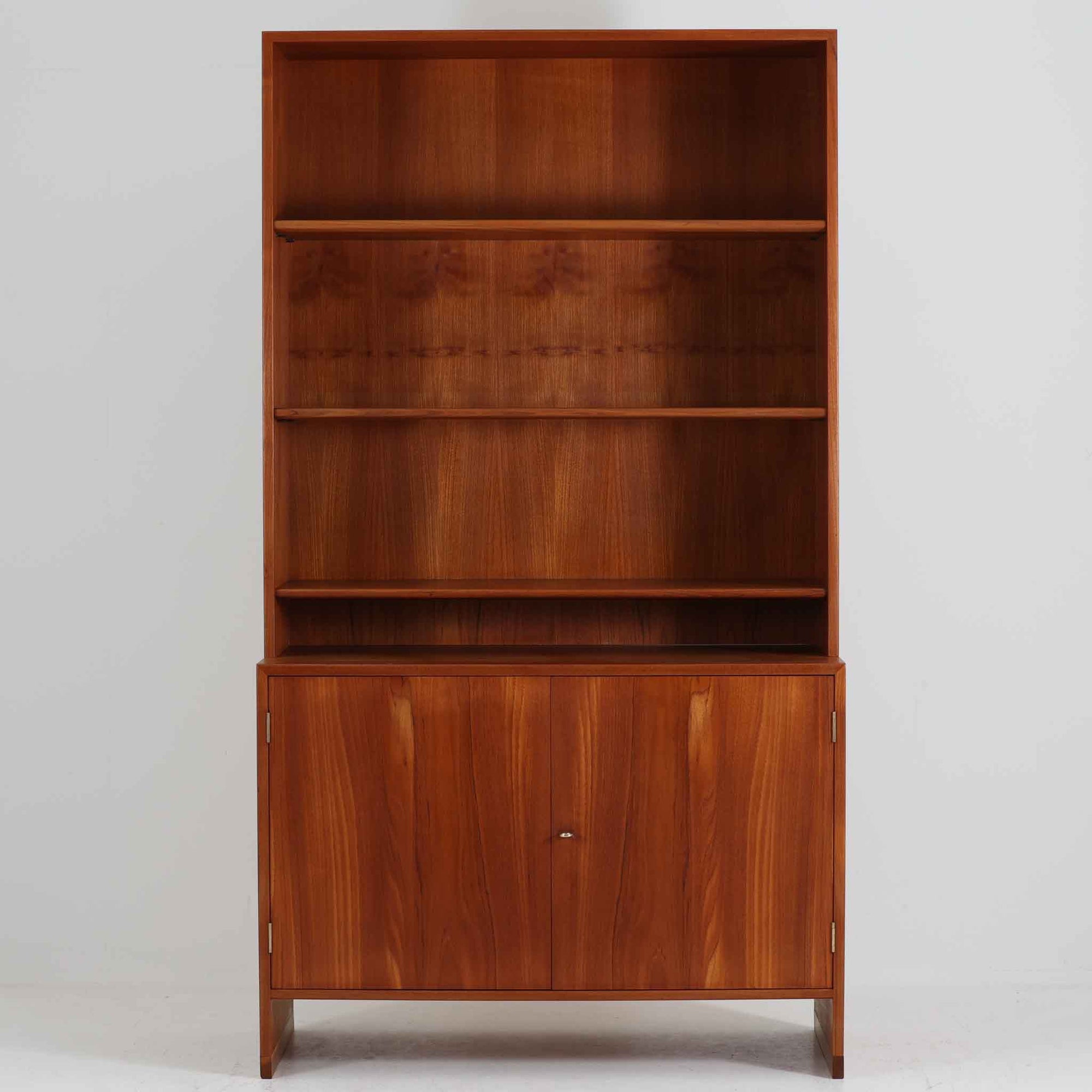 デンマークの巨匠Hans J. Wegner（ハンス・J・ウェグナー）がRY Mobler社のためにデザインしたディスプレイシェルフ「RY5 / RY15」です。上質なチーク材とオーク材を組み合わせ、下段収納部の取手には真鍮を用いた精緻なつくりが特徴です。シンプルながらも素材の美しさが際立ち、ウェグナーらしい温かみのあるデザインに仕上がっています。上段の棚は高さ調整が可能で、下段には仕切り付きの収納スペースを備え、実用性にも優れます。経年により深みを増した木肌の風合いが美しく、リビングや書斎で本や器を飾るなど、多用途に活躍する北欧ビンテージ家具です。