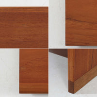 デンマークの巨匠Hans J. Wegner（ハンス・J・ウェグナー）がRY Mobler社のためにデザインしたディスプレイシェルフ「RY5 / RY15」です。上質なチーク材とオーク材を組み合わせ、下段収納部の取手には真鍮を用いた精緻なつくりが特徴です。シンプルながらも素材の美しさが際立ち、ウェグナーらしい温かみのあるデザインに仕上がっています。上段の棚は高さ調整が可能で、下段には仕切り付きの収納スペースを備え、実用性にも優れます。経年により深みを増した木肌の風合いが美しく、リビングや書斎で本や器を飾るなど、多用途に活躍する北欧ビンテージ家具です。