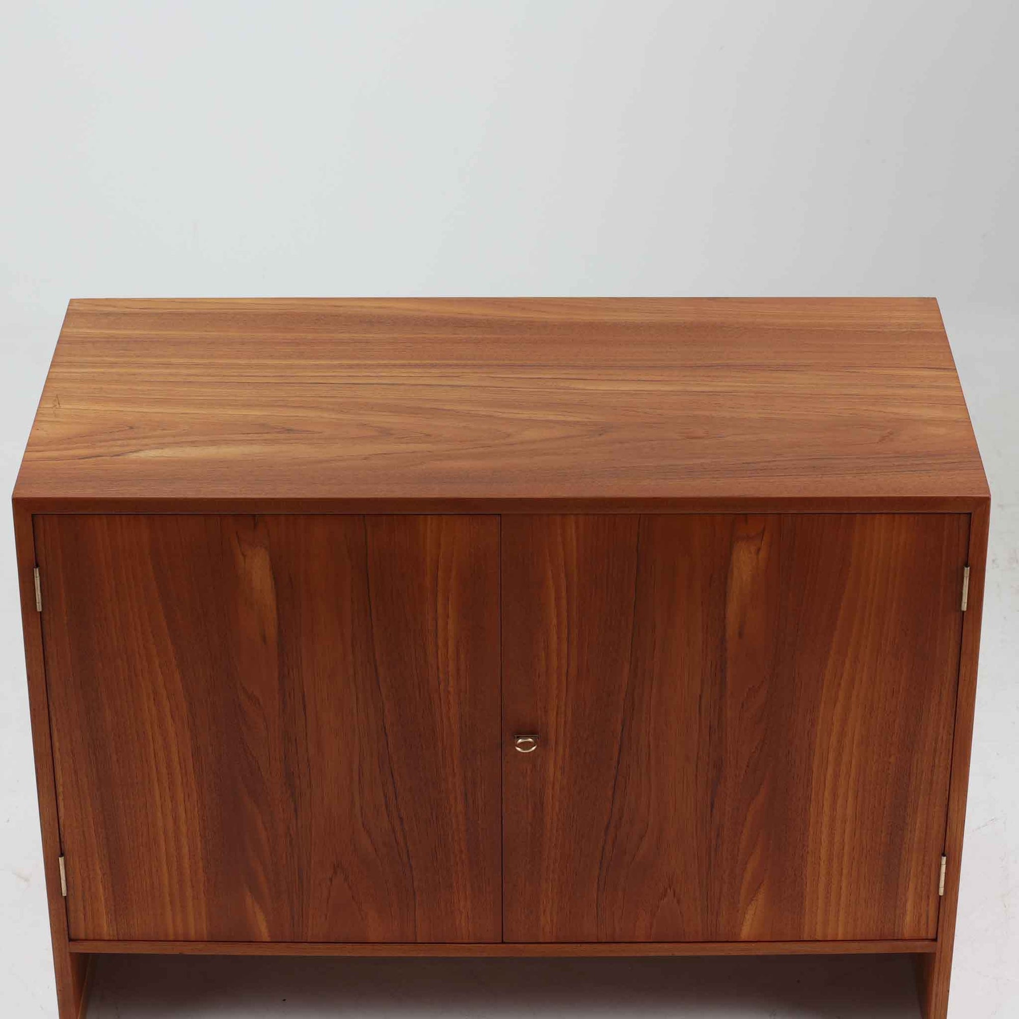 デンマークの巨匠Hans J. Wegner（ハンス・J・ウェグナー）がRY Mobler社のためにデザインしたディスプレイシェルフ「RY5 / RY15」です。上質なチーク材とオーク材を組み合わせ、下段収納部の取手には真鍮を用いた精緻なつくりが特徴です。シンプルながらも素材の美しさが際立ち、ウェグナーらしい温かみのあるデザインに仕上がっています。上段の棚は高さ調整が可能で、下段には仕切り付きの収納スペースを備え、実用性にも優れます。経年により深みを増した木肌の風合いが美しく、リビングや書斎で本や器を飾るなど、多用途に活躍する北欧ビンテージ家具です。