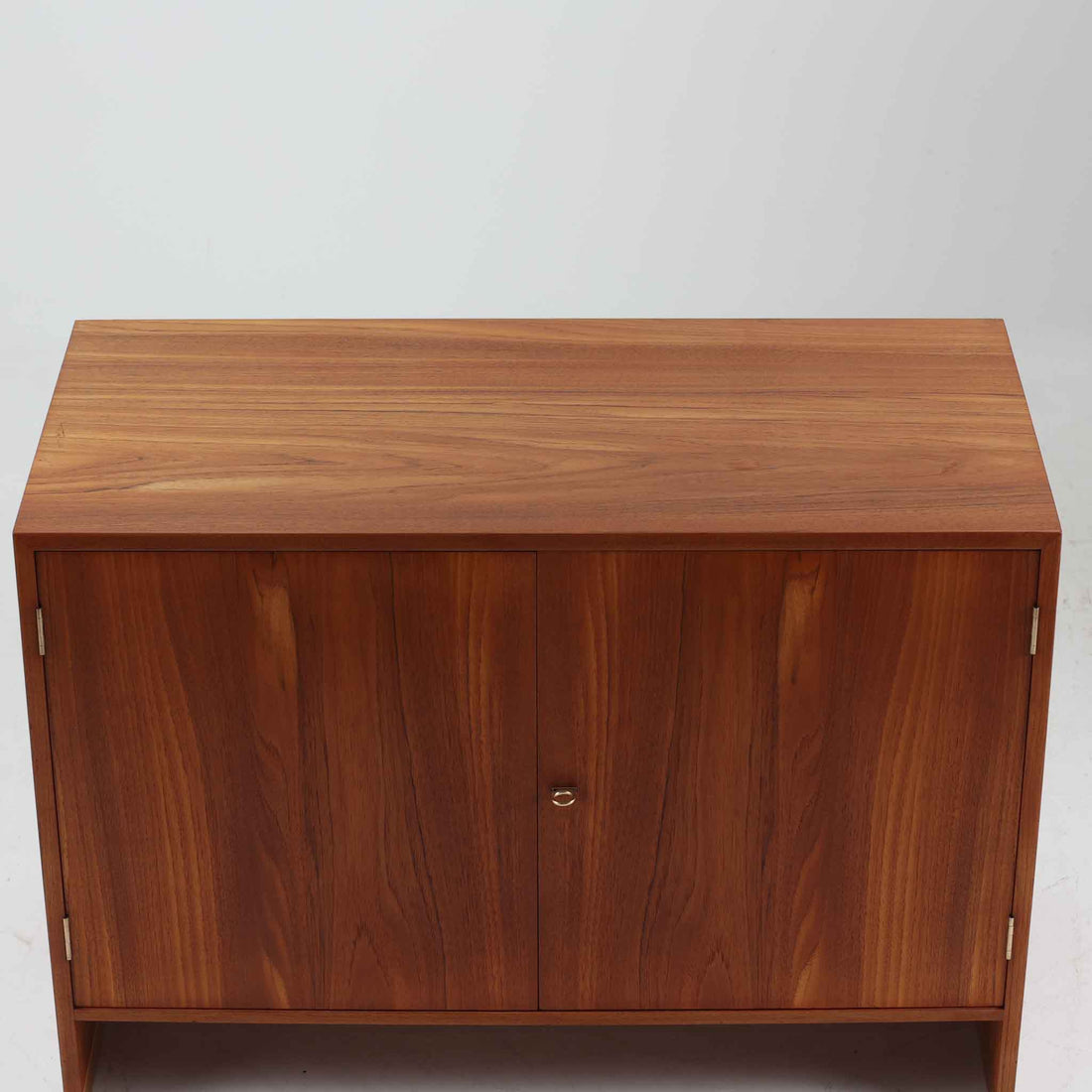 デンマークの巨匠Hans J. Wegner（ハンス・J・ウェグナー）がRY Mobler社のためにデザインしたディスプレイシェルフ「RY5 / RY15」です。上質なチーク材とオーク材を組み合わせ、下段収納部の取手には真鍮を用いた精緻なつくりが特徴です。シンプルながらも素材の美しさが際立ち、ウェグナーらしい温かみのあるデザインに仕上がっています。上段の棚は高さ調整が可能で、下段には仕切り付きの収納スペースを備え、実用性にも優れます。経年により深みを増した木肌の風合いが美しく、リビングや書斎で本や器を飾るなど、多用途に活躍する北欧ビンテージ家具です。