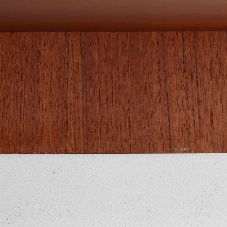 デンマークの巨匠Hans J. Wegner（ハンス・J・ウェグナー）がRY Mobler社のためにデザインしたディスプレイシェルフ「RY5 / RY15」です。上質なチーク材とオーク材を組み合わせ、下段収納部の取手には真鍮を用いた精緻なつくりが特徴です。シンプルながらも素材の美しさが際立ち、ウェグナーらしい温かみのあるデザインに仕上がっています。上段の棚は高さ調整が可能で、下段には仕切り付きの収納スペースを備え、実用性にも優れます。経年により深みを増した木肌の風合いが美しく、リビングや書斎で本や器を飾るなど、多用途に活躍する北欧ビンテージ家具です。