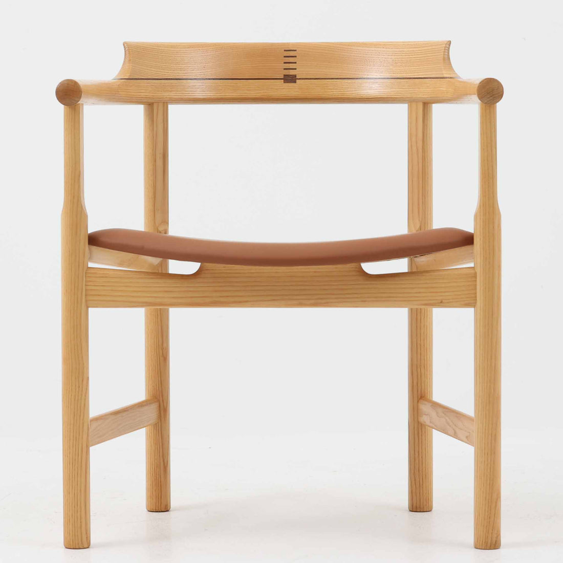 Hans J. Wegnerが1975年にデザインし、PP Mobler社が製造したPP52 Captain's Chairは、背からアームまで滑らかにつながる一体成型の美しいフォルムが魅力のアームチェアです。素材には木目の美しいアッシュ材と本革が用いられ、背面には象徴的な埋木の意匠が施されています。座面はゆったりとしたカーブで快適な座り心地を実現し、ダイニングからデスクシーンまで幅広く対応します。現在も製造されており、現行品の販売価格は約90～100万円程度となっています。