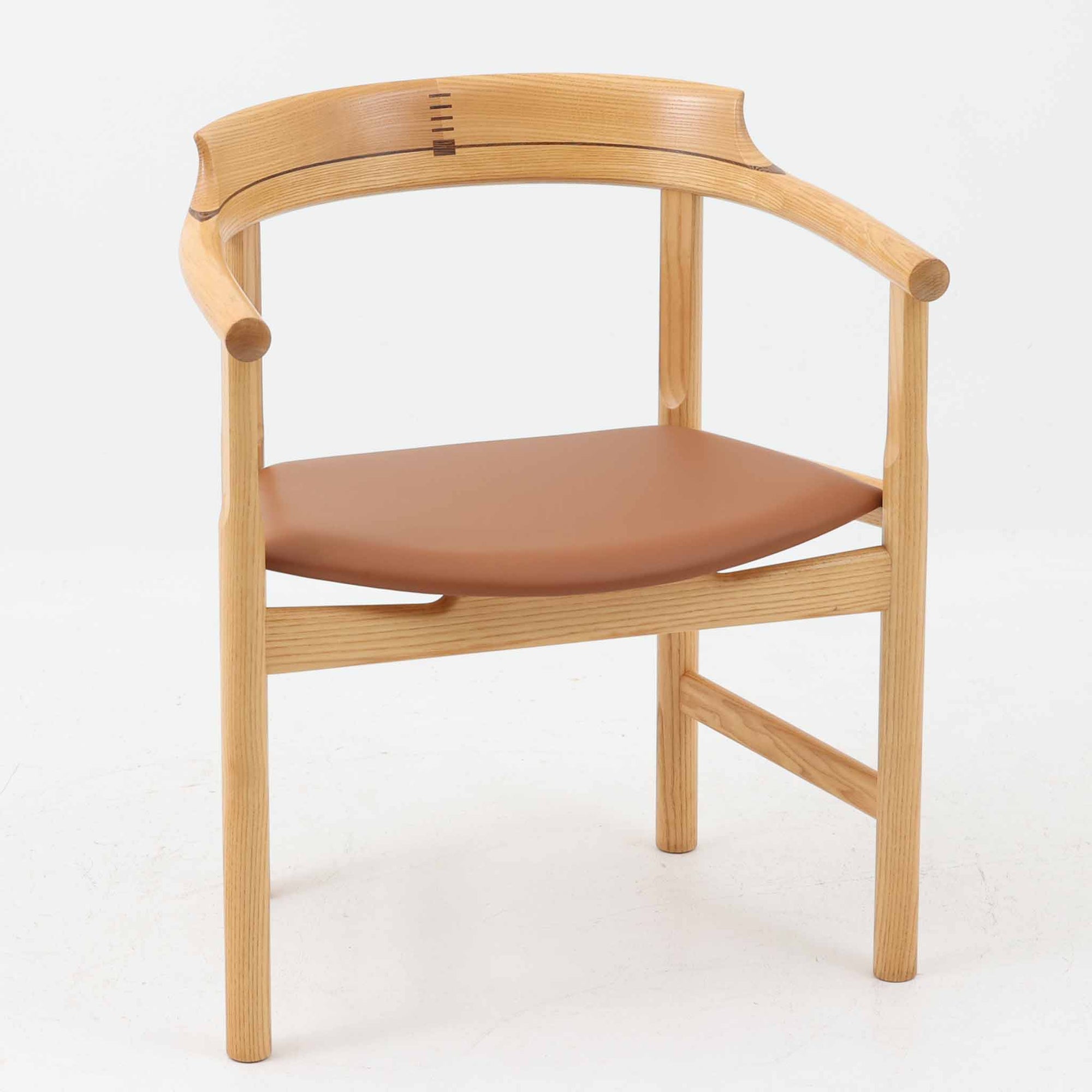 Hans J. Wegnerが1975年にデザインし、PP Mobler社が製造したPP52 Captain's Chairは、背からアームまで滑らかにつながる一体成型の美しいフォルムが魅力のアームチェアです。素材には木目の美しいアッシュ材と本革が用いられ、背面には象徴的な埋木の意匠が施されています。座面はゆったりとしたカーブで快適な座り心地を実現し、ダイニングからデスクシーンまで幅広く対応します。現在も製造されており、現行品の販売価格は約90～100万円程度となっています。