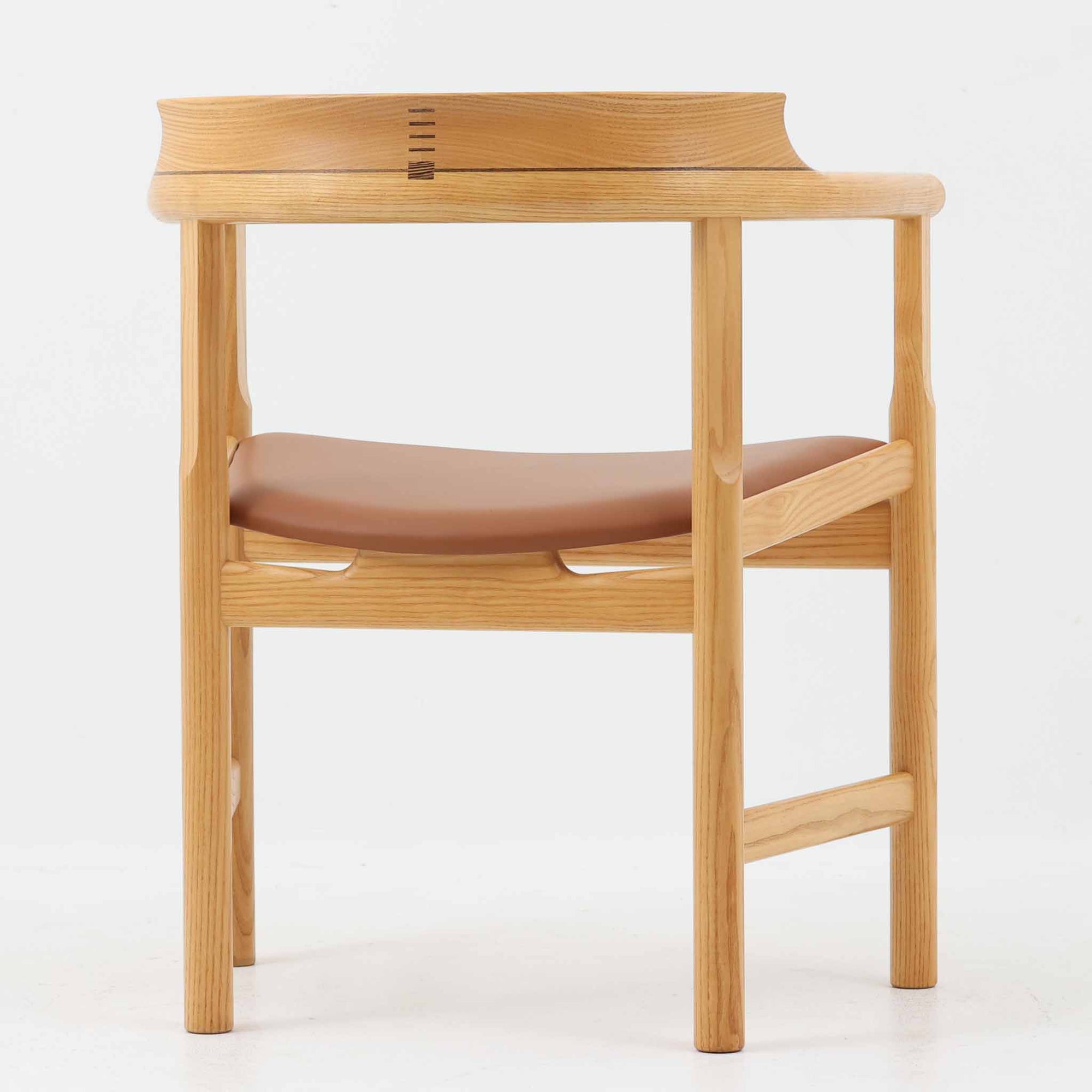 Hans J. Wegnerが1975年にデザインし、PP Mobler社が製造したPP52 Captain's Chairは、背からアームまで滑らかにつながる一体成型の美しいフォルムが魅力のアームチェアです。素材には木目の美しいアッシュ材と本革が用いられ、背面には象徴的な埋木の意匠が施されています。座面はゆったりとしたカーブで快適な座り心地を実現し、ダイニングからデスクシーンまで幅広く対応します。現在も製造されており、現行品の販売価格は約90～100万円程度となっています。