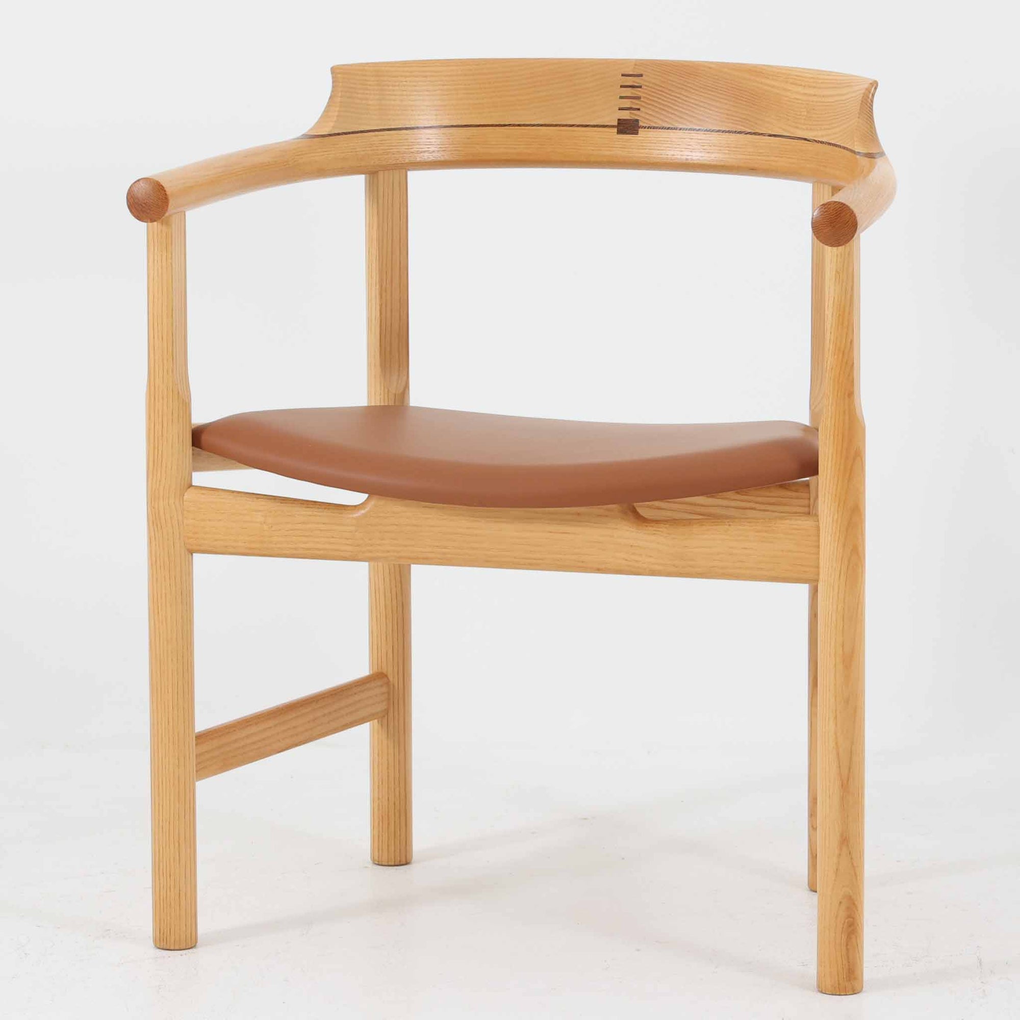 Hans J. Wegnerが1975年にデザインし、PP Mobler社が製造したPP52 Captain's Chairは、背からアームまで滑らかにつながる一体成型の美しいフォルムが魅力のアームチェアです。素材には木目の美しいアッシュ材と本革が用いられ、背面には象徴的な埋木の意匠が施されています。座面はゆったりとしたカーブで快適な座り心地を実現し、ダイニングからデスクシーンまで幅広く対応します。現在も製造されており、現行品の販売価格は約90～100万円程度となっています。
