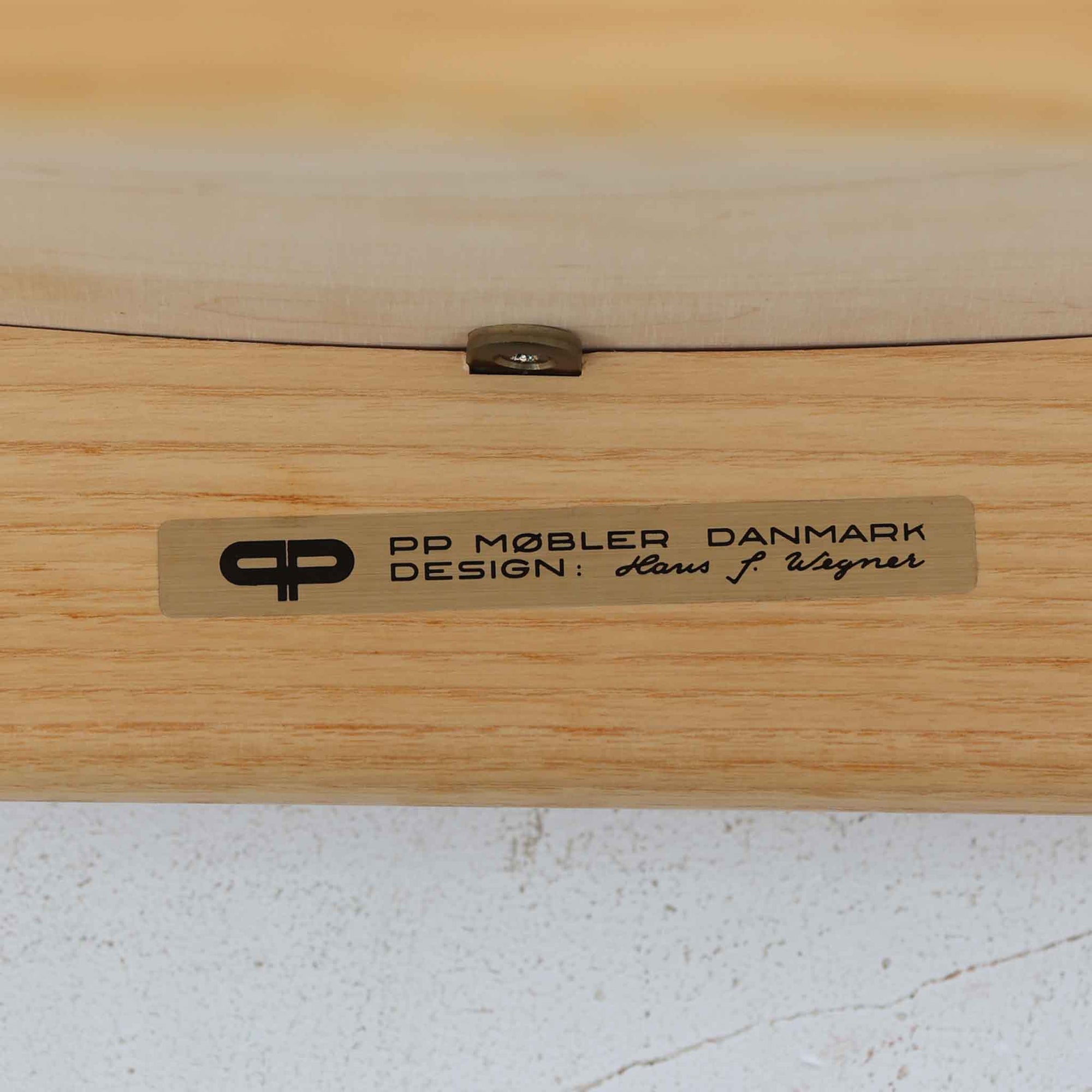 Hans J. Wegnerが1975年にデザインし、PP Mobler社が製造したPP52 Captain's Chairは、背からアームまで滑らかにつながる一体成型の美しいフォルムが魅力のアームチェアです。素材には木目の美しいアッシュ材と本革が用いられ、背面には象徴的な埋木の意匠が施されています。座面はゆったりとしたカーブで快適な座り心地を実現し、ダイニングからデスクシーンまで幅広く対応します。現在も製造されており、現行品の販売価格は約90～100万円程度となっています。