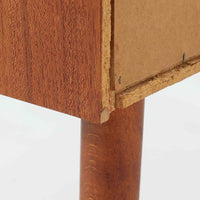 チーク材を使用したデンマーク製の3段チェストで、直線的な本体に対して丸みを帯びた引き手と細身のテーパードレッグが柔らかな印象を与え、さらに天板左右に伸びた耳のような張り出しがデザインのアクセントとなり、北欧らしい優雅な佇まいが感じられます。引き出しは3杯備え、衣類や小物収納に適したサイズ感で、ベッドサイドやリビングの一角に置きやすく、花器や照明のディスプレイ台としても楽しめます。シンプルな造形ながら木目の美しさが際立ち、空間に温かみと落ち着きを添えてくれるビンテージ家具です。