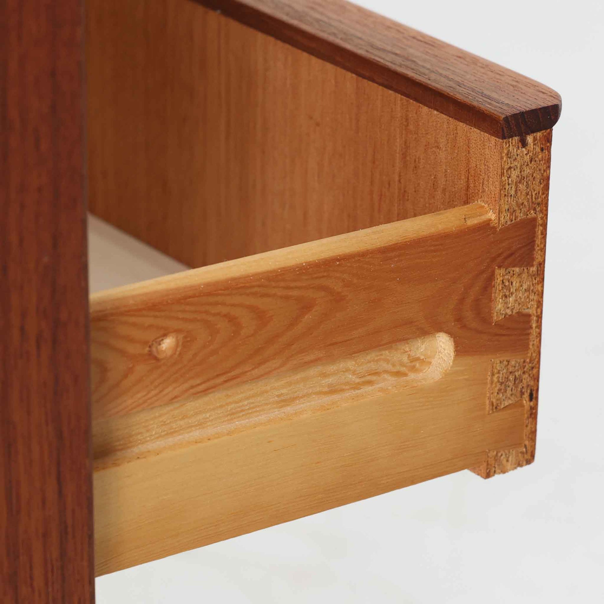 チーク材を使用したデンマーク製の3段チェストで、直線的な本体に対して丸みを帯びた引き手と細身のテーパードレッグが柔らかな印象を与え、さらに天板左右に伸びた耳のような張り出しがデザインのアクセントとなり、北欧らしい優雅な佇まいが感じられます。引き出しは3杯備え、衣類や小物収納に適したサイズ感で、ベッドサイドやリビングの一角に置きやすく、花器や照明のディスプレイ台としても楽しめます。シンプルな造形ながら木目の美しさが際立ち、空間に温かみと落ち着きを添えてくれるビンテージ家具です。