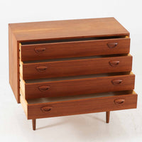 カイ・クリスチャンセンが手掛け、フェルドバレス・モーベルファブリック社によって製作された4段チェストは、北欧ビンテージらしい端正な佇まいと高い実用性を兼ね備えた一台です。良質なチーク材を用いた本体は、木目の美しさが前面に表れ、半円状に削り出された取手や細身のテーパードレッグが、全体に軽やかで洗練された印象を与えています。引き出しは深さにゆとりがあり収納力も十分で、衣類や小物の整理に最適です。経年変化によって深みを増したチークの色合いが空間に温もりを添え、リビングや寝室、書斎など幅広いシーンで主役として活躍します。