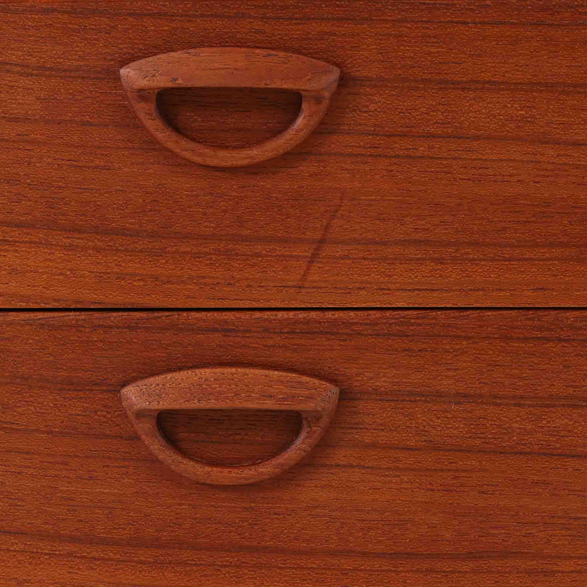 カイ・クリスチャンセンが手掛け、フェルドバレス・モーベルファブリック社によって製作された4段チェストは、北欧ビンテージらしい端正な佇まいと高い実用性を兼ね備えた一台です。良質なチーク材を用いた本体は、木目の美しさが前面に表れ、半円状に削り出された取手や細身のテーパードレッグが、全体に軽やかで洗練された印象を与えています。引き出しは深さにゆとりがあり収納力も十分で、衣類や小物の整理に最適です。経年変化によって深みを増したチークの色合いが空間に温もりを添え、リビングや寝室、書斎など幅広いシーンで主役として活躍します。