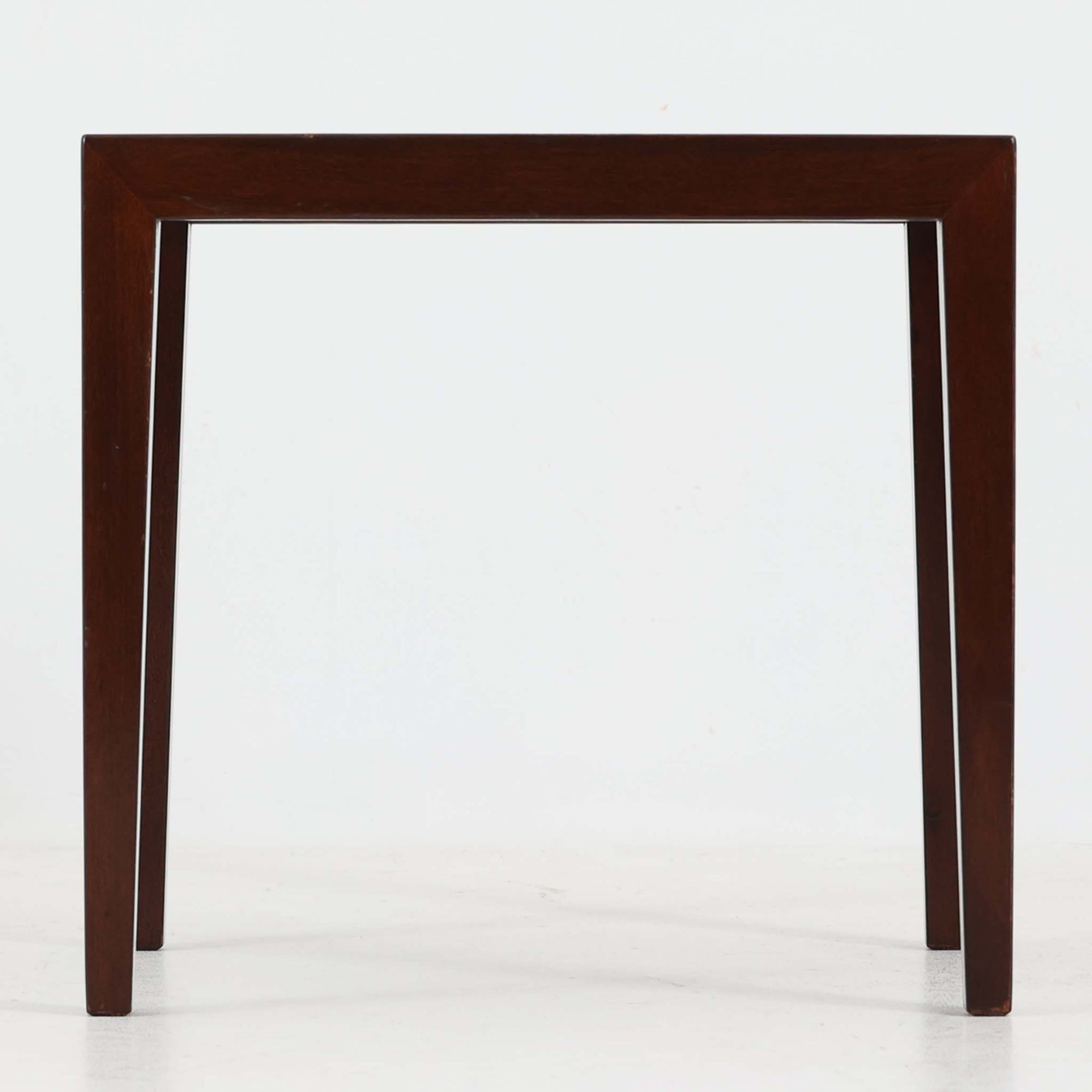 Severin Hansen Jr.（セヴェリン・ハンセン）がデザインし、Haslev社より製造されたタイルトップテーブルで、天板にはNils ThorssonによるBACAシリーズの陶板が贅沢にあしらわれています。端正な角脚を持つマホガニー材のフレームは、ハンセンらしいシャープなジョイントが際立ち、凛とした佇まいを演出します。耐熱性に優れたタイルは日常使いに適しており、サイドテーブルや植物のディスプレイスペースとしても活躍。経年により深みを増した木肌とBACA特有の芸術性が空間に上質なアクセントを添えるビンテージ品です。