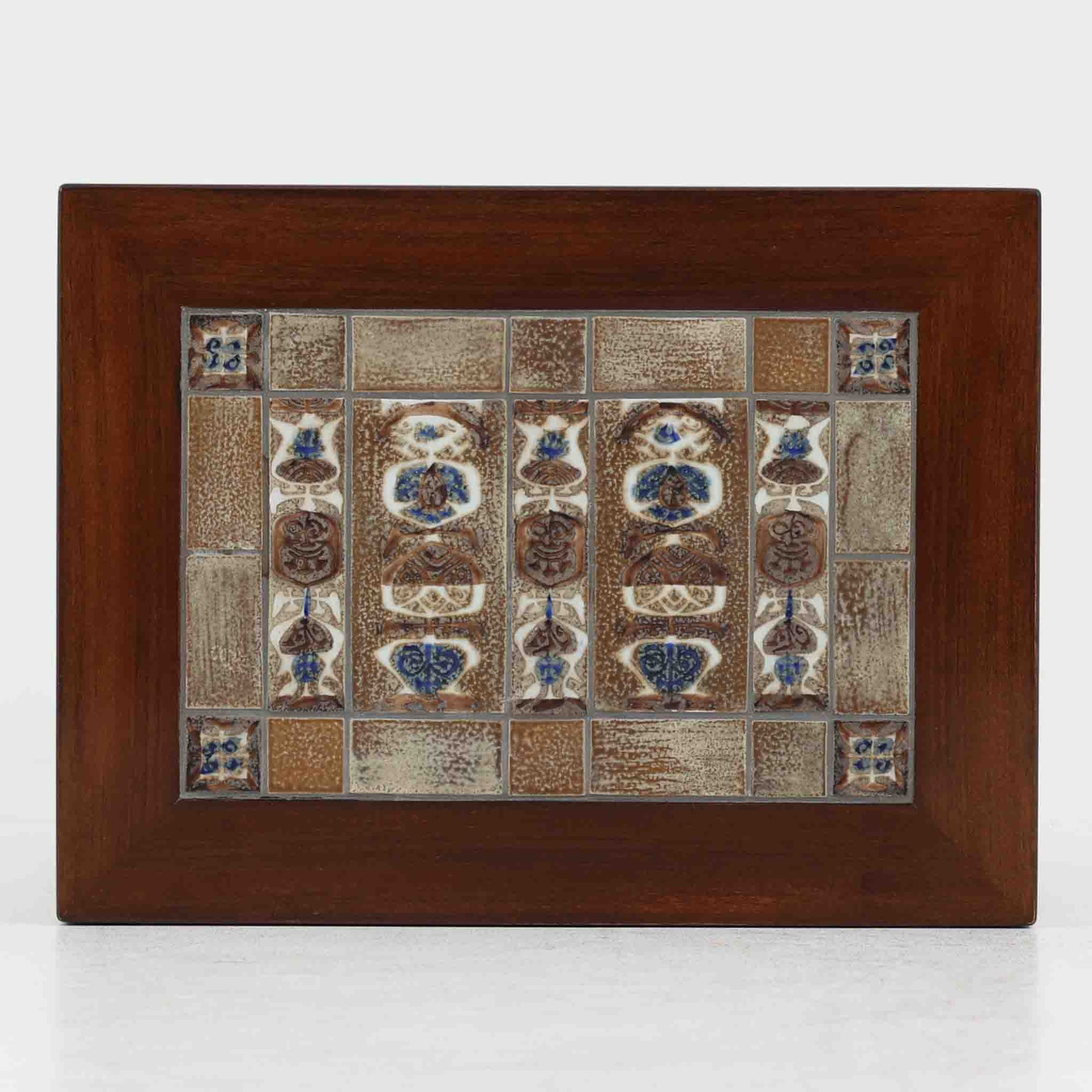 Severin Hansen Jr.（セヴェリン・ハンセン）がデザインし、Haslev社より製造されたタイルトップテーブルで、天板にはNils ThorssonによるBACAシリーズの陶板が贅沢にあしらわれています。端正な角脚を持つマホガニー材のフレームは、ハンセンらしいシャープなジョイントが際立ち、凛とした佇まいを演出します。耐熱性に優れたタイルは日常使いに適しており、サイドテーブルや植物のディスプレイスペースとしても活躍。経年により深みを増した木肌とBACA特有の芸術性が空間に上質なアクセントを添えるビンテージ品です。