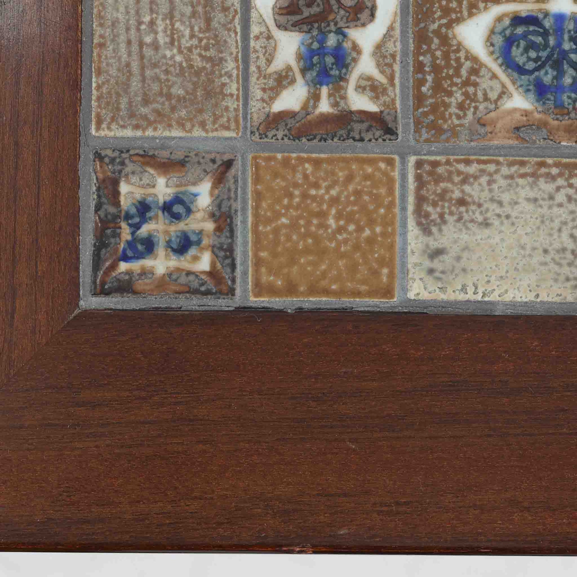 Severin Hansen Jr.（セヴェリン・ハンセン）がデザインし、Haslev社より製造されたタイルトップテーブルで、天板にはNils ThorssonによるBACAシリーズの陶板が贅沢にあしらわれています。端正な角脚を持つマホガニー材のフレームは、ハンセンらしいシャープなジョイントが際立ち、凛とした佇まいを演出します。耐熱性に優れたタイルは日常使いに適しており、サイドテーブルや植物のディスプレイスペースとしても活躍。経年により深みを増した木肌とBACA特有の芸術性が空間に上質なアクセントを添えるビンテージ品です。