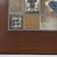 Severin Hansen Jr.（セヴェリン・ハンセン）がデザインし、Haslev社より製造されたタイルトップテーブルで、天板にはNils ThorssonによるBACAシリーズの陶板が贅沢にあしらわれています。端正な角脚を持つマホガニー材のフレームは、ハンセンらしいシャープなジョイントが際立ち、凛とした佇まいを演出します。耐熱性に優れたタイルは日常使いに適しており、サイドテーブルや植物のディスプレイスペースとしても活躍。経年により深みを増した木肌とBACA特有の芸術性が空間に上質なアクセントを添えるビンテージ品です。