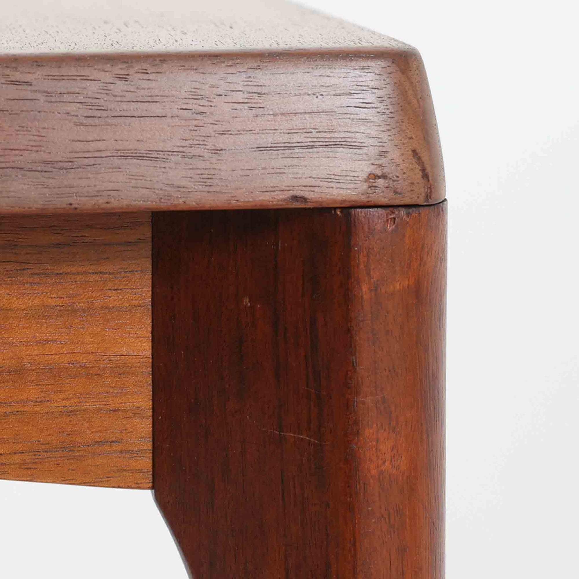 Henning Kjaernulf（ヘニング・ケアヌルフ）によるデザイン、Vejle Stole og Mobelfabrik社製のセンターテーブルです。チーク材特有の深みある色合いと美しい木目が際立ち、北欧家具らしい上質な雰囲気を漂わせます。脚部から幕板にかけての滑らかな曲線が職人技を感じさせ、どの角度から見ても整った美しいフォルムが魅力です。リビングの中心で穏やかな存在感を放ち、ソファとの相性も抜群。経年により増した艶が、ビンテージ家具ならではの温もりを感じさせます。なお、天板や幕板はチーク材と思われ、脚部にはチークに近い色調と質感をもつアフロモシア材が使用されている可能性があります。