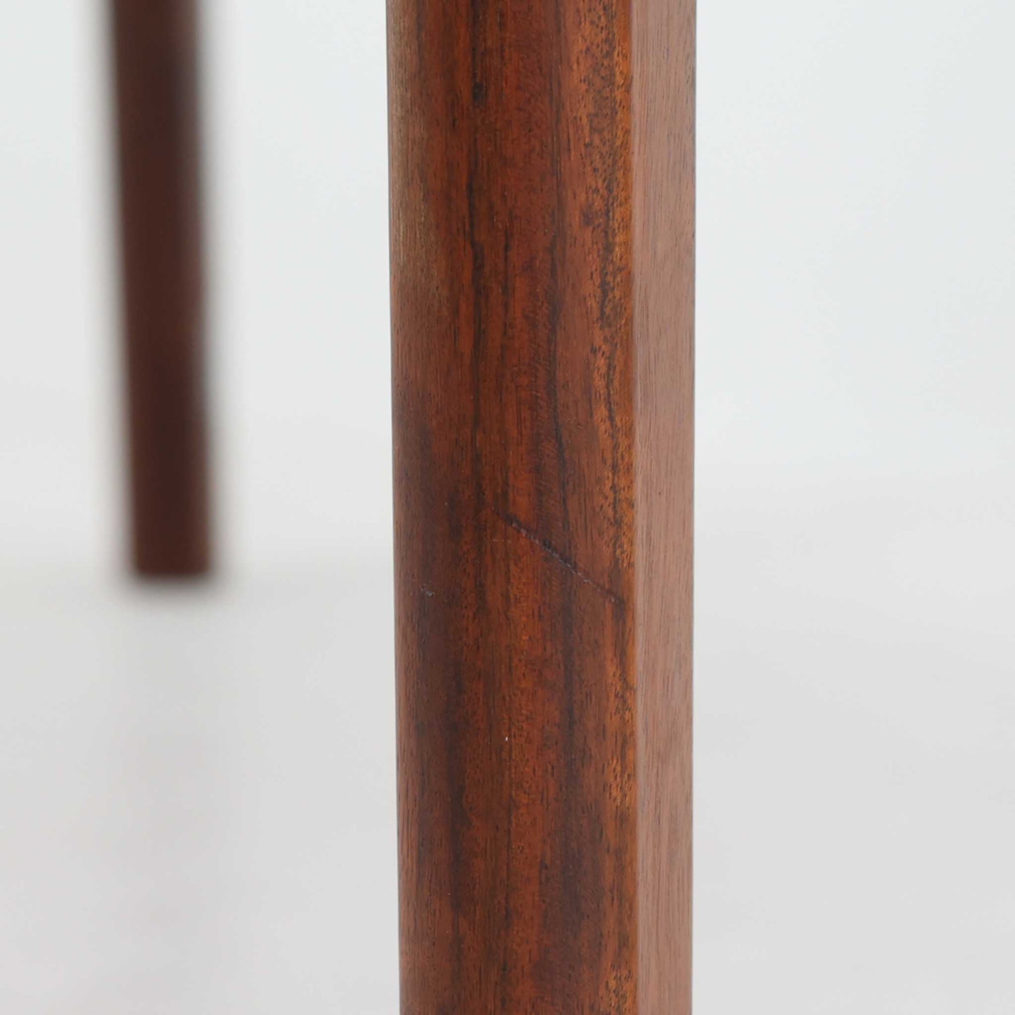 Henning Kjaernulf（ヘニング・ケアヌルフ）によるデザイン、Vejle Stole og Mobelfabrik社製のセンターテーブルです。チーク材特有の深みある色合いと美しい木目が際立ち、北欧家具らしい上質な雰囲気を漂わせます。脚部から幕板にかけての滑らかな曲線が職人技を感じさせ、どの角度から見ても整った美しいフォルムが魅力です。リビングの中心で穏やかな存在感を放ち、ソファとの相性も抜群。経年により増した艶が、ビンテージ家具ならではの温もりを感じさせます。なお、天板や幕板はチーク材と思われ、脚部にはチークに近い色調と質感をもつアフロモシア材が使用されている可能性があります。