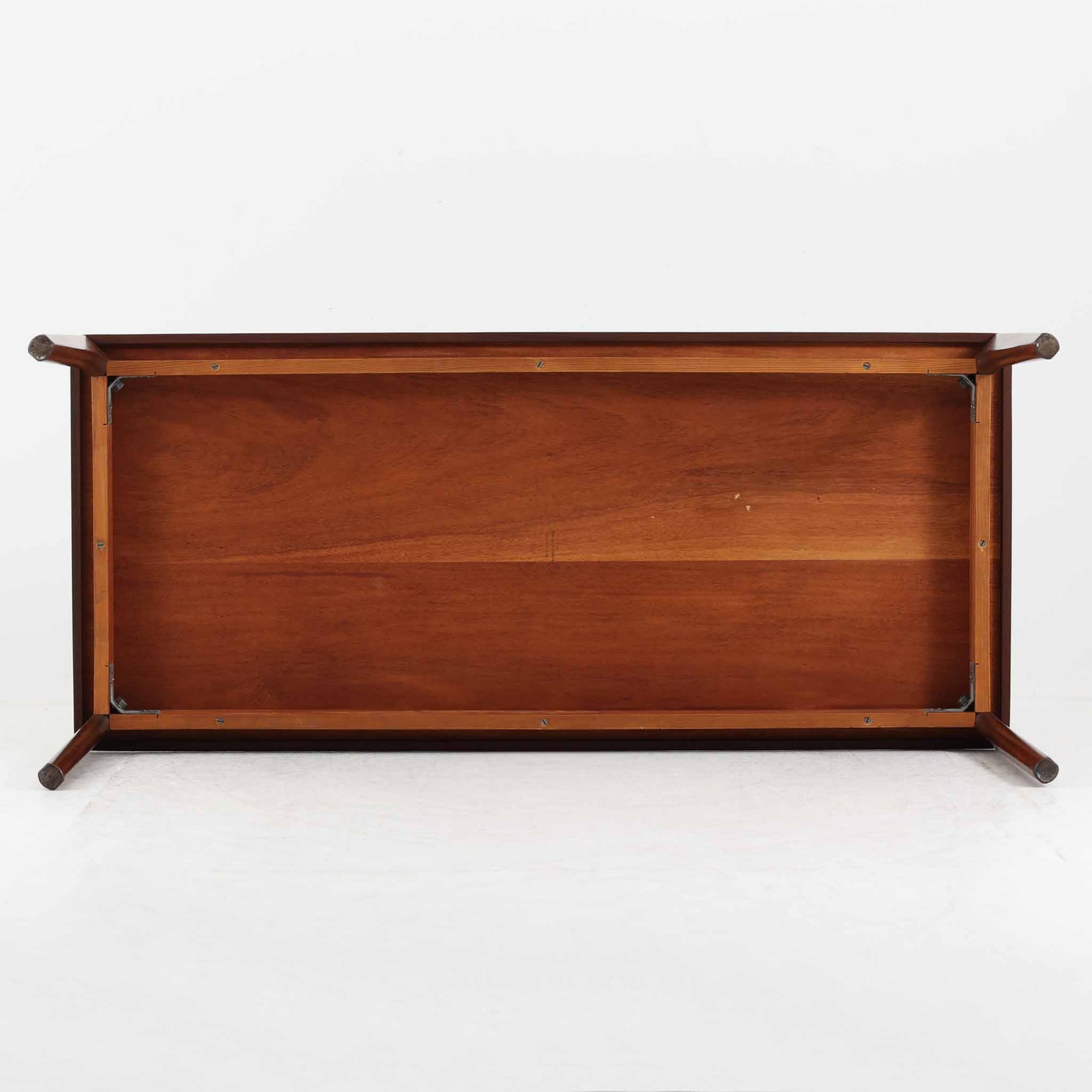 Henning Kjaernulf（ヘニング・ケアヌルフ）によるデザイン、Vejle Stole og Mobelfabrik社製のセンターテーブルです。チーク材特有の深みある色合いと美しい木目が際立ち、北欧家具らしい上質な雰囲気を漂わせます。脚部から幕板にかけての滑らかな曲線が職人技を感じさせ、どの角度から見ても整った美しいフォルムが魅力です。リビングの中心で穏やかな存在感を放ち、ソファとの相性も抜群。経年により増した艶が、ビンテージ家具ならではの温もりを感じさせます。なお、天板や幕板はチーク材と思われ、脚部にはチークに近い色調と質感をもつアフロモシア材が使用されている可能性があります。