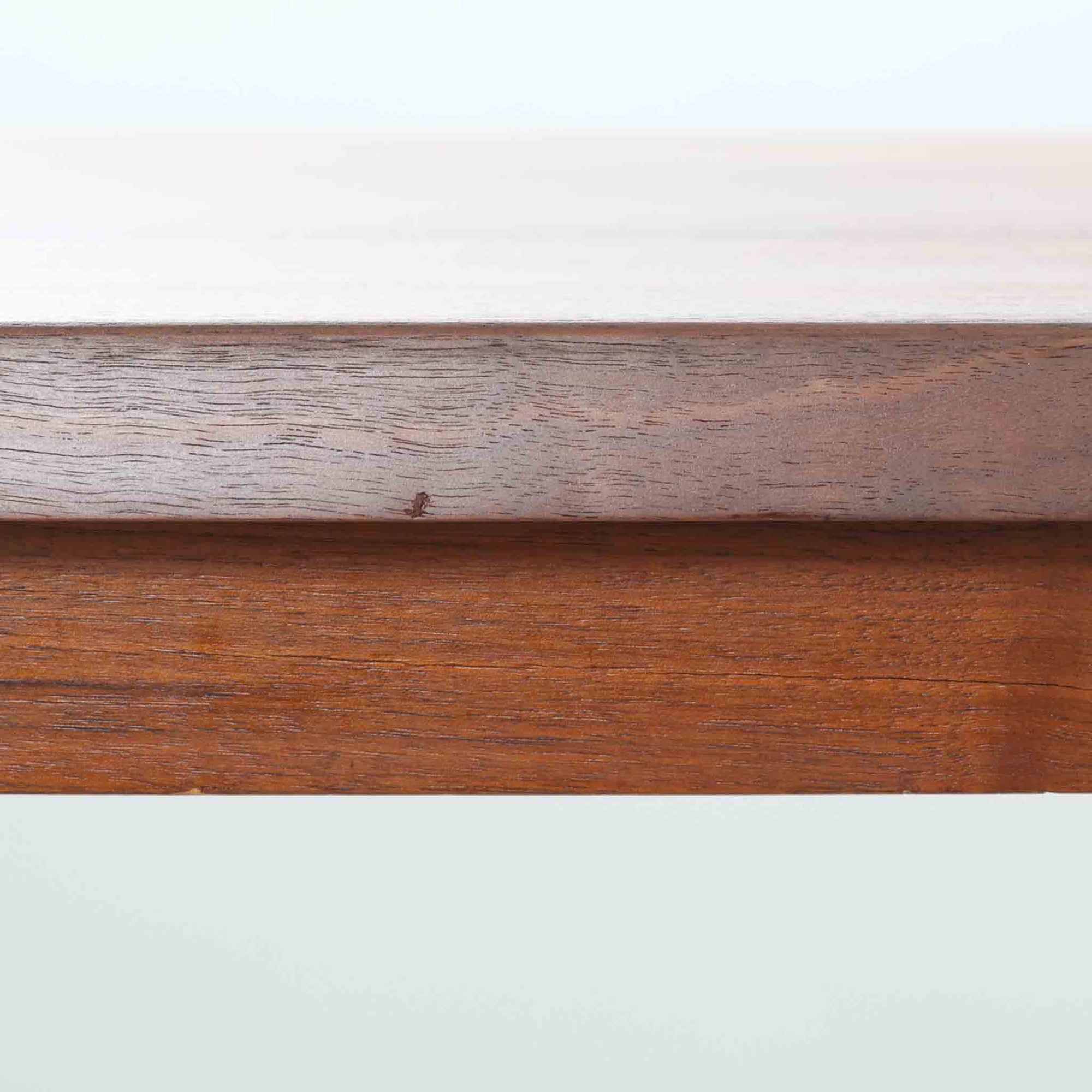 Henning Kjaernulf（ヘニング・ケアヌルフ）によるデザイン、Vejle Stole og Mobelfabrik社製のセンターテーブルです。チーク材特有の深みある色合いと美しい木目が際立ち、北欧家具らしい上質な雰囲気を漂わせます。脚部から幕板にかけての滑らかな曲線が職人技を感じさせ、どの角度から見ても整った美しいフォルムが魅力です。リビングの中心で穏やかな存在感を放ち、ソファとの相性も抜群。経年により増した艶が、ビンテージ家具ならではの温もりを感じさせます。なお、天板や幕板はチーク材と思われ、脚部にはチークに近い色調と質感をもつアフロモシア材が使用されている可能性があります。