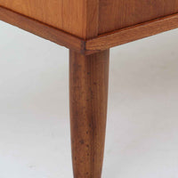 デンマーク製のチーク材3段チェストです。前板の一体的なデザインが美しく、取手部分を削り出した滑らかなラインが上品な印象を与えます。幅が77cmと少し大きめで、コンパクトながら収納力があり、寝室や玄関、リビングのサイド収納としても活躍します。最上段には鍵付きの引き出しが設けられ、大切な書類や貴重品の保管にも便利です。脚部まで丁寧に仕上げられた造りは北欧家具ならではの職人技を感じさせ、空間に温もりを添えてくれます。