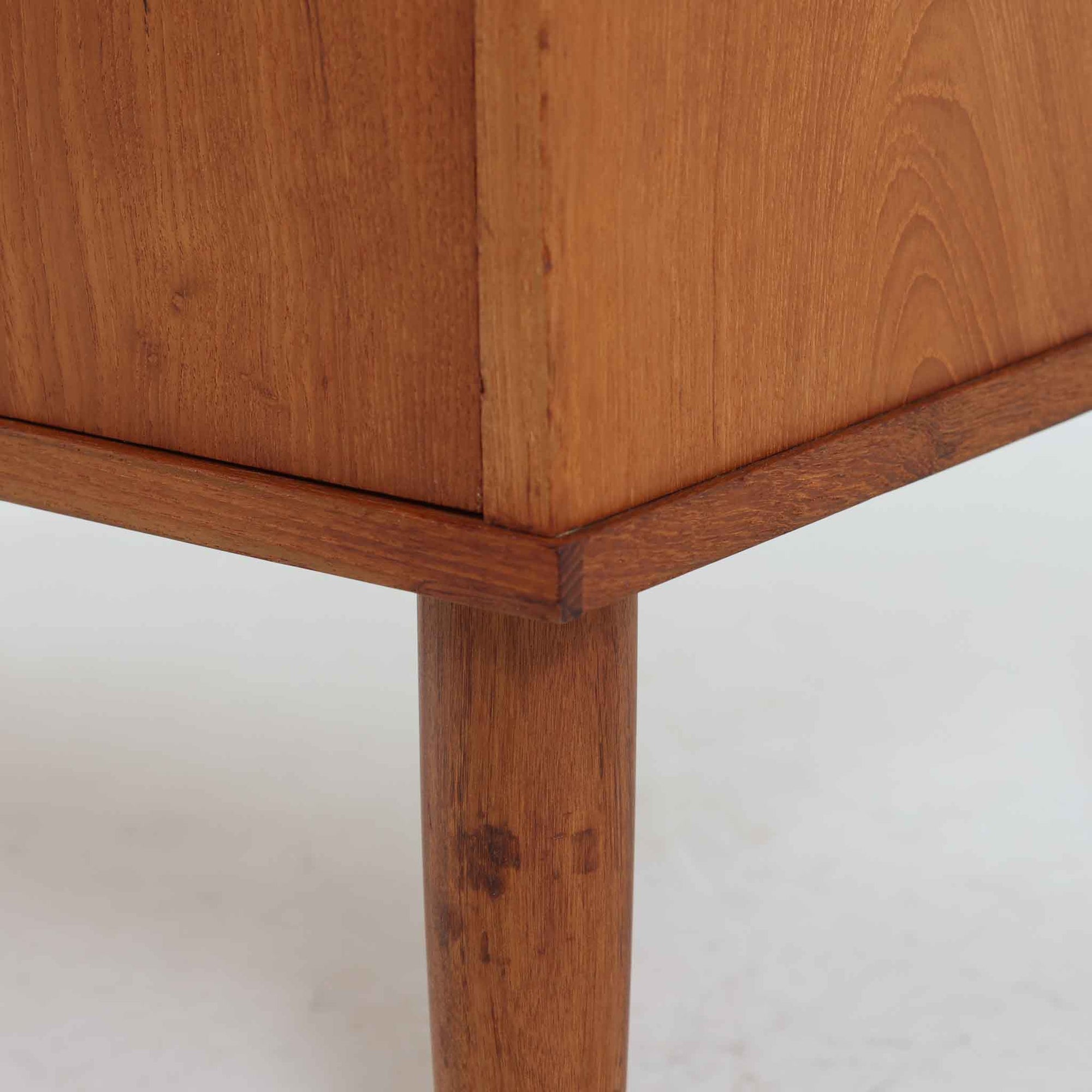 デンマーク製のチーク材3段チェストです。前板の一体的なデザインが美しく、取手部分を削り出した滑らかなラインが上品な印象を与えます。幅が77cmと少し大きめで、コンパクトながら収納力があり、寝室や玄関、リビングのサイド収納としても活躍します。最上段には鍵付きの引き出しが設けられ、大切な書類や貴重品の保管にも便利です。脚部まで丁寧に仕上げられた造りは北欧家具ならではの職人技を感じさせ、空間に温もりを添えてくれます。