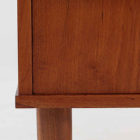 デンマーク製のチーク材3段チェストです。前板の一体的なデザインが美しく、取手部分を削り出した滑らかなラインが上品な印象を与えます。幅が77cmと少し大きめで、コンパクトながら収納力があり、寝室や玄関、リビングのサイド収納としても活躍します。最上段には鍵付きの引き出しが設けられ、大切な書類や貴重品の保管にも便利です。脚部まで丁寧に仕上げられた造りは北欧家具ならではの職人技を感じさせ、空間に温もりを添えてくれます。