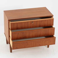 デンマーク製のチーク材3段チェストです。前板の一体的なデザインが美しく、取手部分を削り出した滑らかなラインが上品な印象を与えます。幅が77cmと少し大きめで、コンパクトながら収納力があり、寝室や玄関、リビングのサイド収納としても活躍します。最上段には鍵付きの引き出しが設けられ、大切な書類や貴重品の保管にも便利です。脚部まで丁寧に仕上げられた造りは北欧家具ならではの職人技を感じさせ、空間に温もりを添えてくれます。