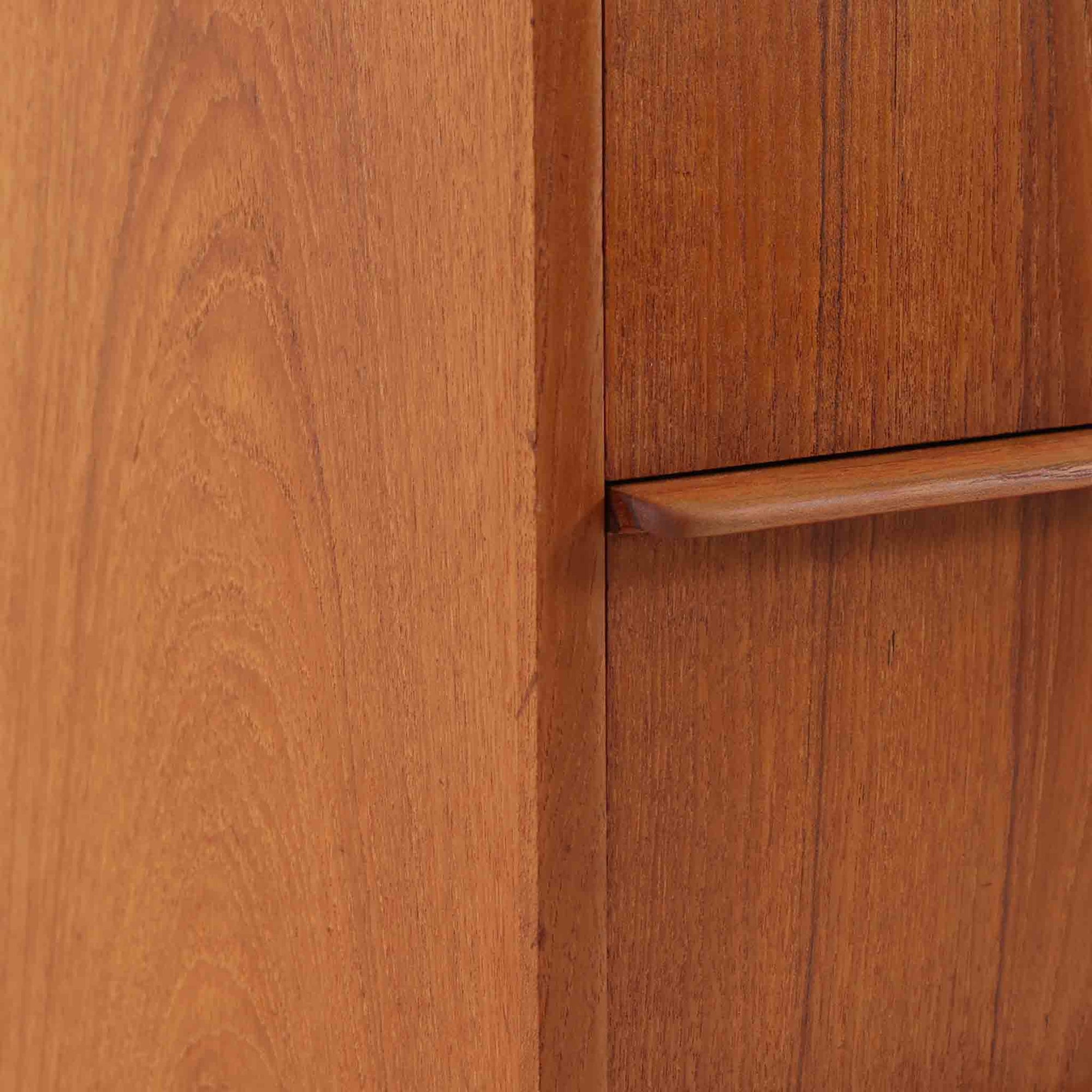 デンマーク製のチーク材3段チェストです。前板の一体的なデザインが美しく、取手部分を削り出した滑らかなラインが上品な印象を与えます。幅が77cmと少し大きめで、コンパクトながら収納力があり、寝室や玄関、リビングのサイド収納としても活躍します。最上段には鍵付きの引き出しが設けられ、大切な書類や貴重品の保管にも便利です。脚部まで丁寧に仕上げられた造りは北欧家具ならではの職人技を感じさせ、空間に温もりを添えてくれます。