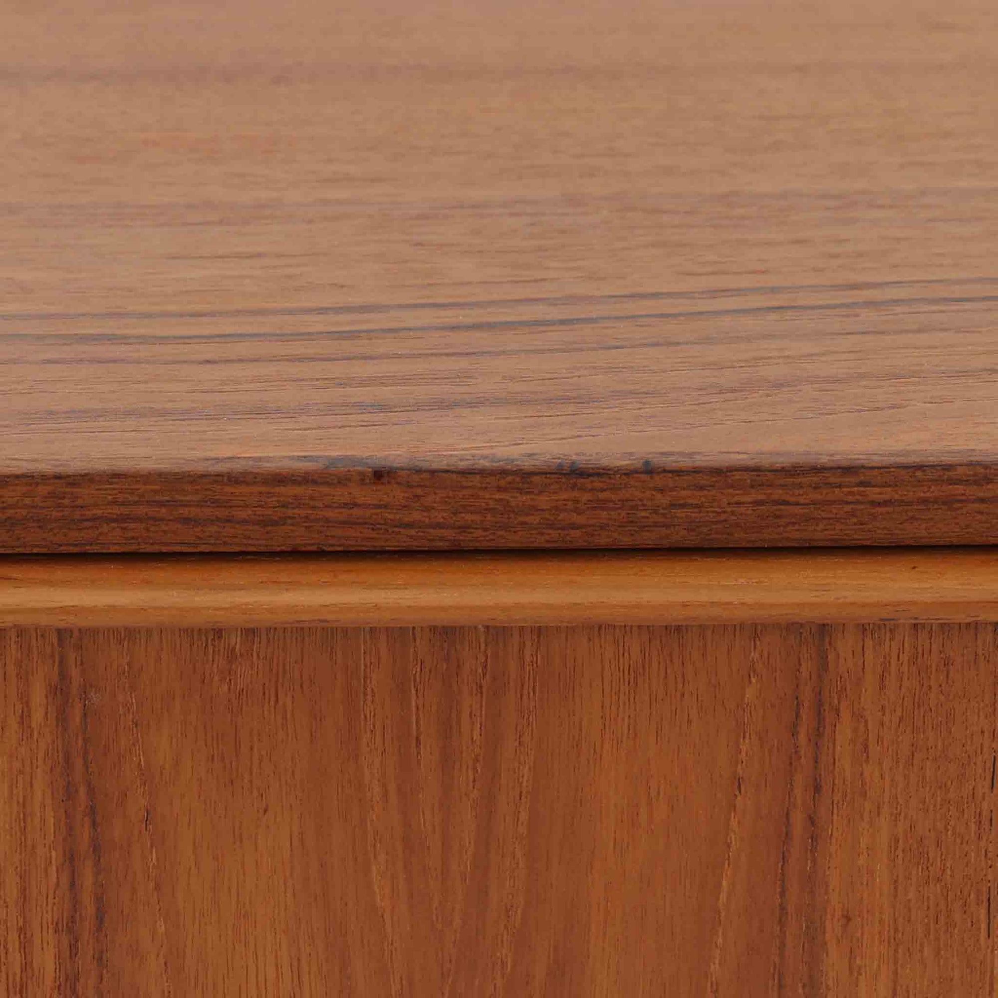 デンマーク製のチーク材3段チェストです。前板の一体的なデザインが美しく、取手部分を削り出した滑らかなラインが上品な印象を与えます。幅が77cmと少し大きめで、コンパクトながら収納力があり、寝室や玄関、リビングのサイド収納としても活躍します。最上段には鍵付きの引き出しが設けられ、大切な書類や貴重品の保管にも便利です。脚部まで丁寧に仕上げられた造りは北欧家具ならではの職人技を感じさせ、空間に温もりを添えてくれます。