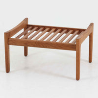 ハンス・J・ウェグナーがデザインし、ゲタマ社から発表されたGE290オットマンは、堅牢なオーク材のフレームと、ウール混紡のざっくりとした風合いを持つ落ち着いたグリーン系の張地が美しく調和した北欧ビンテージ家具です。直線的でありながら丸みを帯びた脚部が軽快な印象を与え、ソファと組み合わせてフットレストとして、あるいは単体で腰掛けとしてもお使いいただけます。経年によって深まった木肌の風合いと上質な張地が空間に落ち着いた存在感をもたらし、クッション内部にはビンテージ品ならではのスプリングが内包されています。