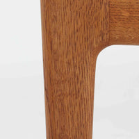 ハンス・J・ウェグナーがデザインし、ゲタマ社から発表されたGE290オットマンは、堅牢なオーク材のフレームと、ウール混紡のざっくりとした風合いを持つ落ち着いたグリーン系の張地が美しく調和した北欧ビンテージ家具です。直線的でありながら丸みを帯びた脚部が軽快な印象を与え、ソファと組み合わせてフットレストとして、あるいは単体で腰掛けとしてもお使いいただけます。経年によって深まった木肌の風合いと上質な張地が空間に落ち着いた存在感をもたらし、クッション内部にはビンテージ品ならではのスプリングが内包されています。