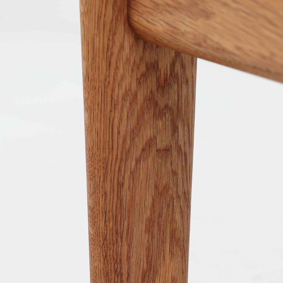 ハンス・J・ウェグナーがデザインし、ゲタマ社から発表されたGE290オットマンは、堅牢なオーク材のフレームと、ウール混紡のざっくりとした風合いを持つ落ち着いたグリーン系の張地が美しく調和した北欧ビンテージ家具です。直線的でありながら丸みを帯びた脚部が軽快な印象を与え、ソファと組み合わせてフットレストとして、あるいは単体で腰掛けとしてもお使いいただけます。経年によって深まった木肌の風合いと上質な張地が空間に落ち着いた存在感をもたらし、クッション内部にはビンテージ品ならではのスプリングが内包されています。