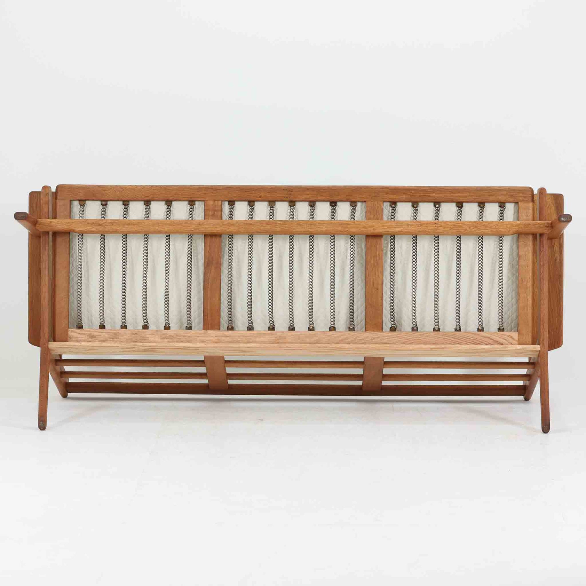 Hans J. Wegnerがデザインし、Getamaより製造された名作ソファ「GE290」です。オーク材の美しい木目を活かした堅牢なフレームと、背面まで美しく仕上げられたスポーク構造が特徴で、空間の中央にも映える洗練された佇まいを備えています。ゆったりとした3人掛けの座面は快適な掛け心地を実現し、リビングの主役として長く愛用できる一台。時代を超えて評価されるウェグナーならではの機能美と、ビンテージならではの味わい深い経年変化を存分に楽しめる北欧家具です。