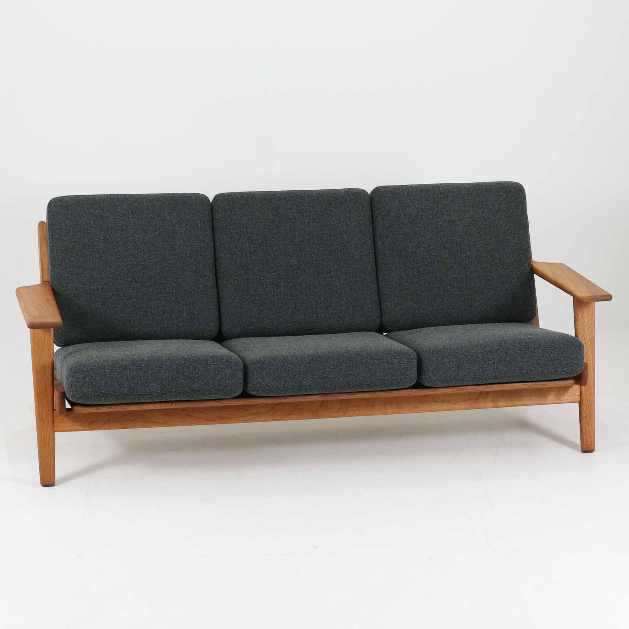 Hans J. Wegnerがデザインし、Getamaより製造された名作ソファ「GE290」です。オーク材の美しい木目を活かした堅牢なフレームと、背面まで美しく仕上げられたスポーク構造が特徴で、空間の中央にも映える洗練された佇まいを備えています。ゆったりとした3人掛けの座面は快適な掛け心地を実現し、リビングの主役として長く愛用できる一台。時代を超えて評価されるウェグナーならではの機能美と、ビンテージならではの味わい深い経年変化を存分に楽しめる北欧家具です。