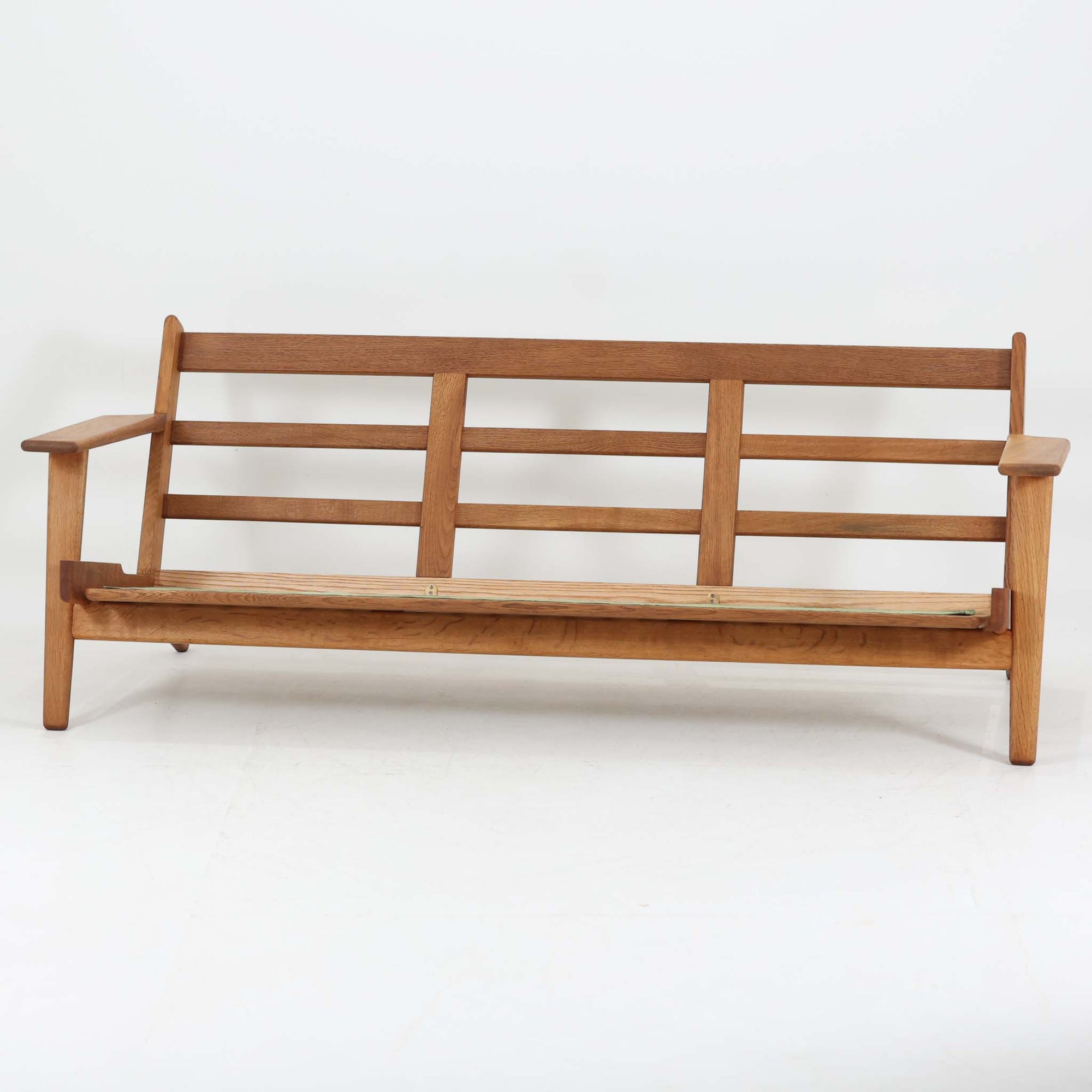 Hans J. Wegnerがデザインし、Getamaより製造された名作ソファ「GE290」です。オーク材の美しい木目を活かした堅牢なフレームと、背面まで美しく仕上げられたスポーク構造が特徴で、空間の中央にも映える洗練された佇まいを備えています。ゆったりとした3人掛けの座面は快適な掛け心地を実現し、リビングの主役として長く愛用できる一台。時代を超えて評価されるウェグナーならではの機能美と、ビンテージならではの味わい深い経年変化を存分に楽しめる北欧家具です。